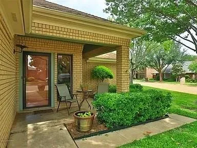 Brick exterior with a covered entry, glass-paneled door, and adjacent window