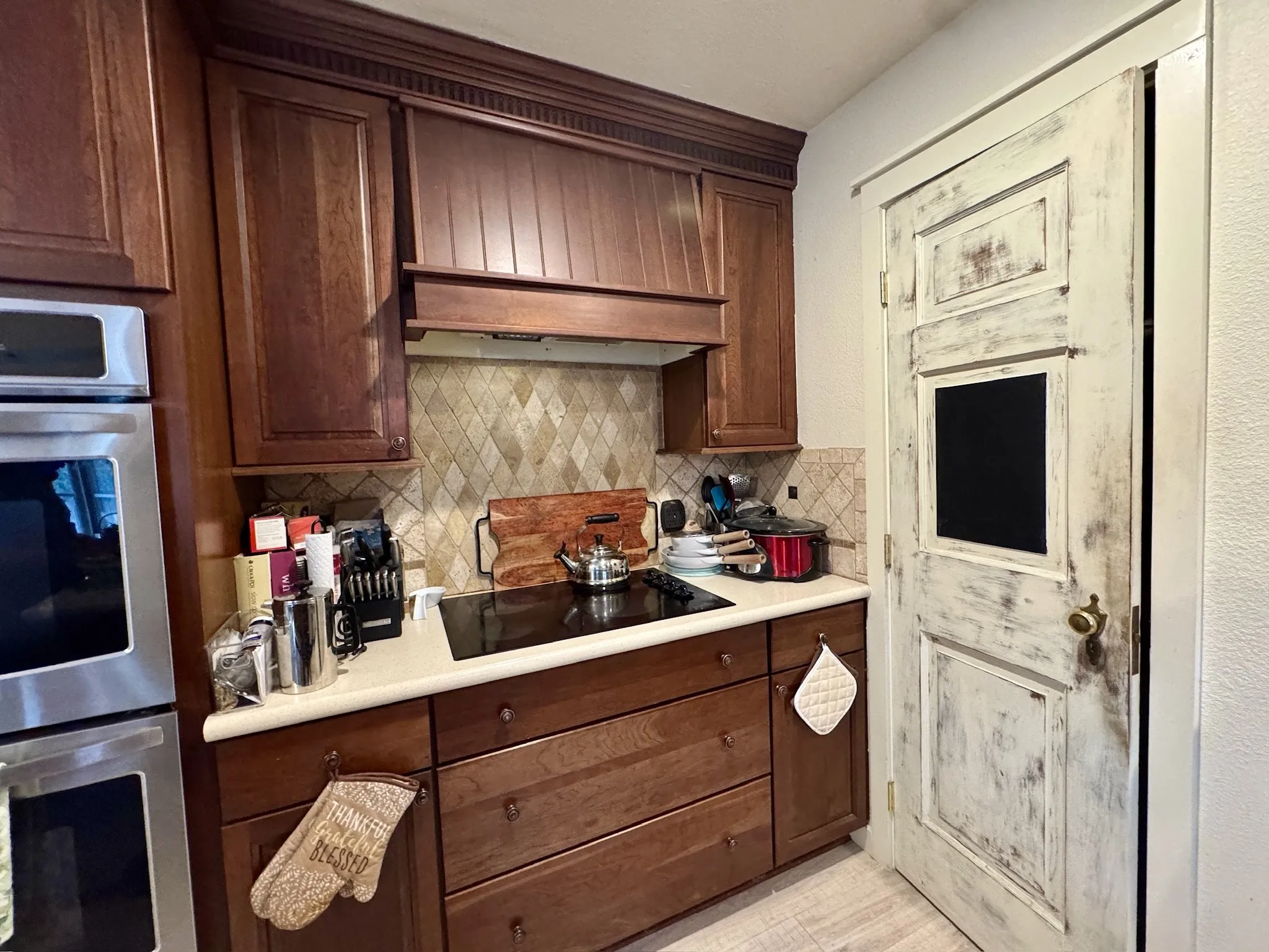 Double oven, electric stove, & custom pantry door.