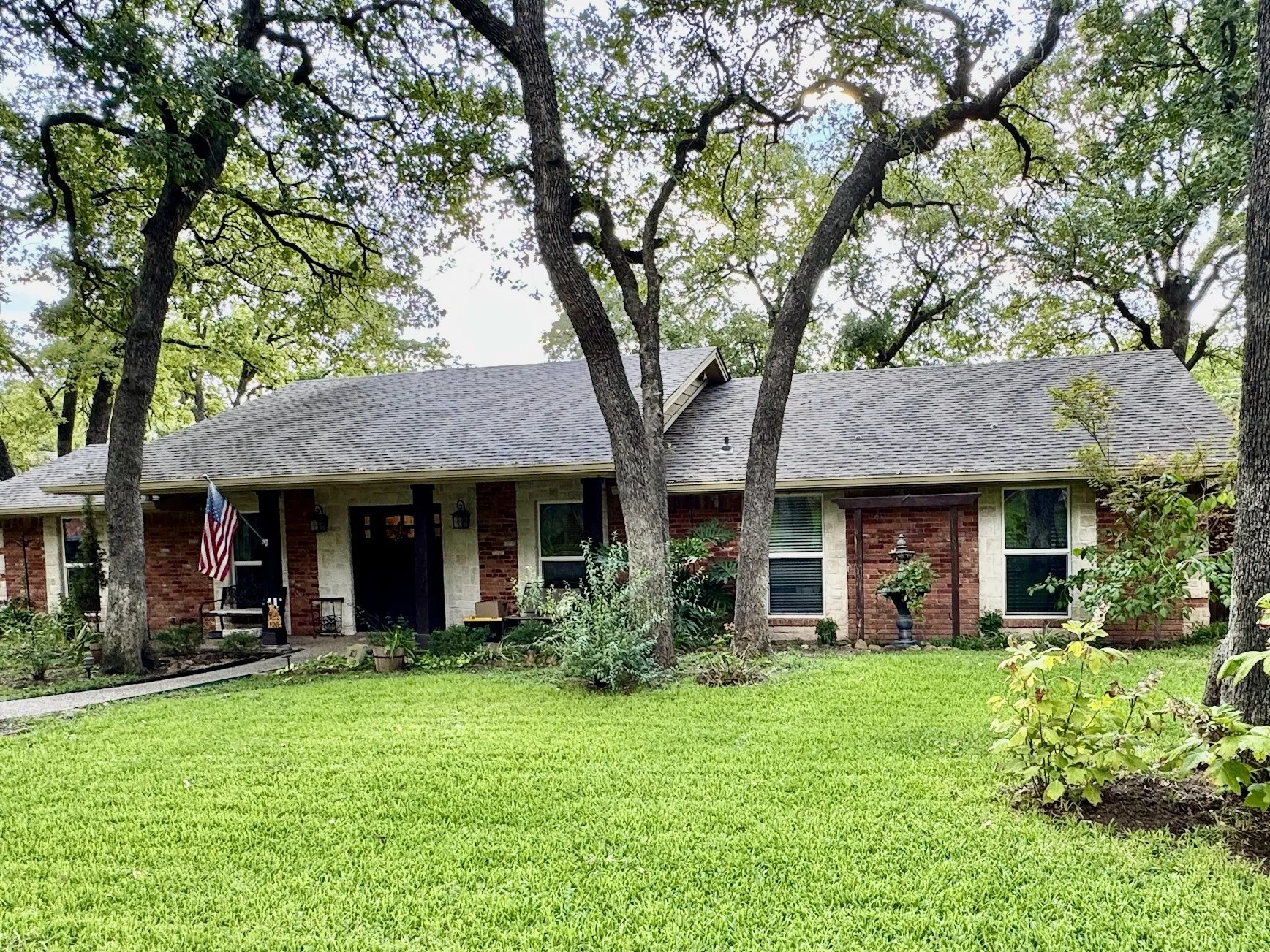 Lush St. Augustine grass front with tall oak trees.