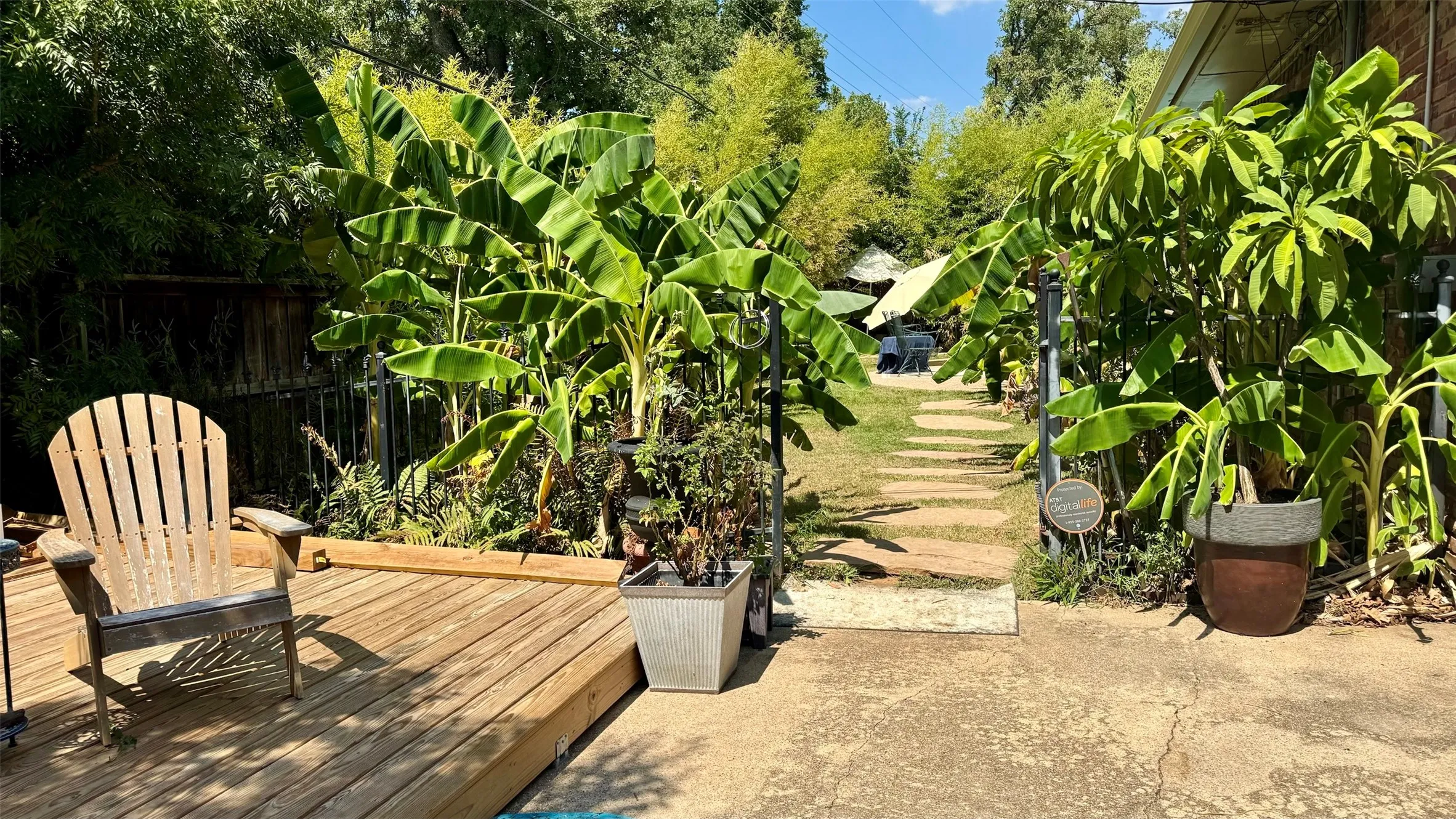 14’ x 14’ deck at the end of the driveway sits next to the iron gate entrance into your backyard oasis.