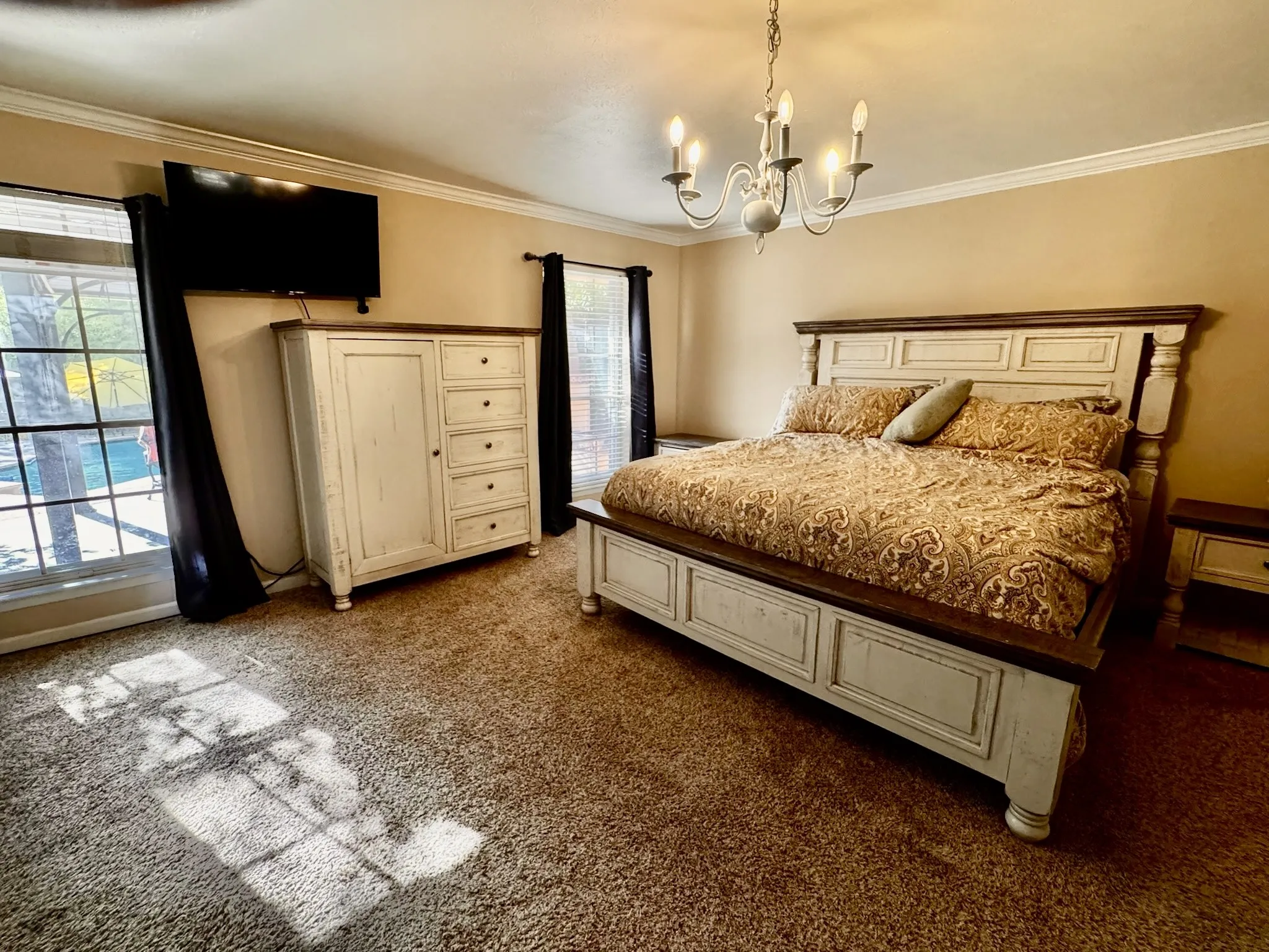 Primary bedroom overlooks the backyard pool and pergola.