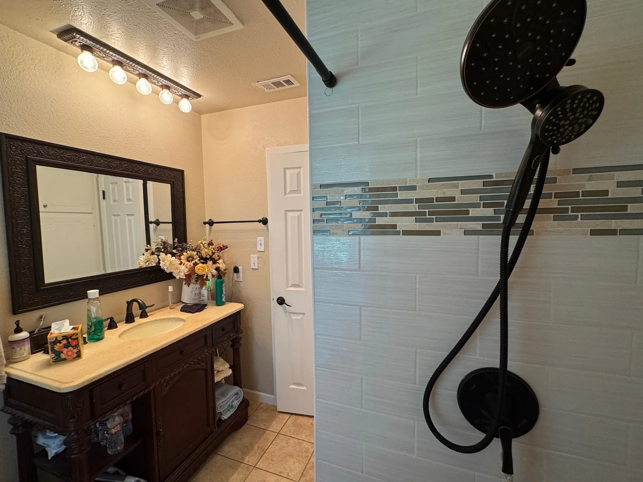 Hall bathroom shower with multiple heads.