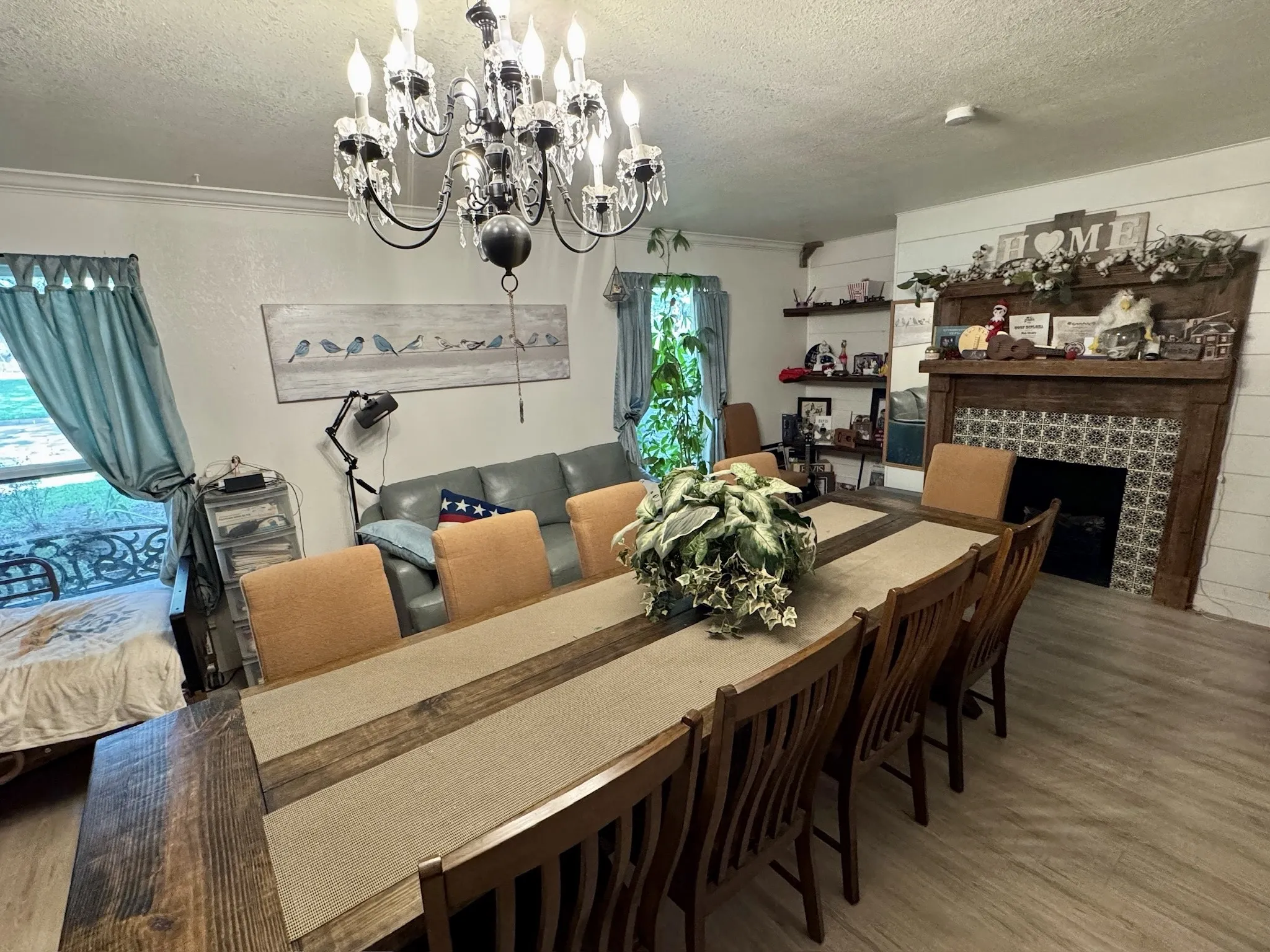 Room easily accommodates an oversized dining table perfect for your gatherings, with a chandelier, & decorative fireplace.