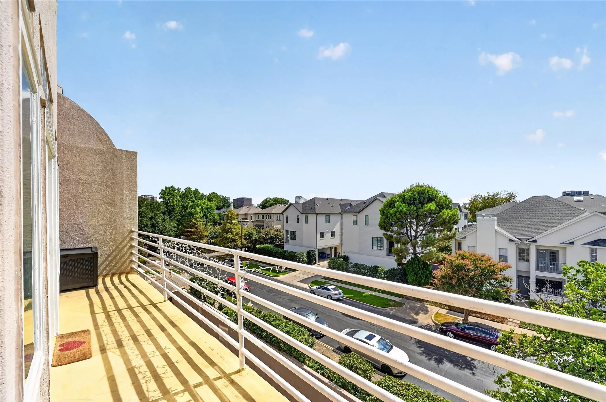 Exterior balcony with a metal railing and stucco wall