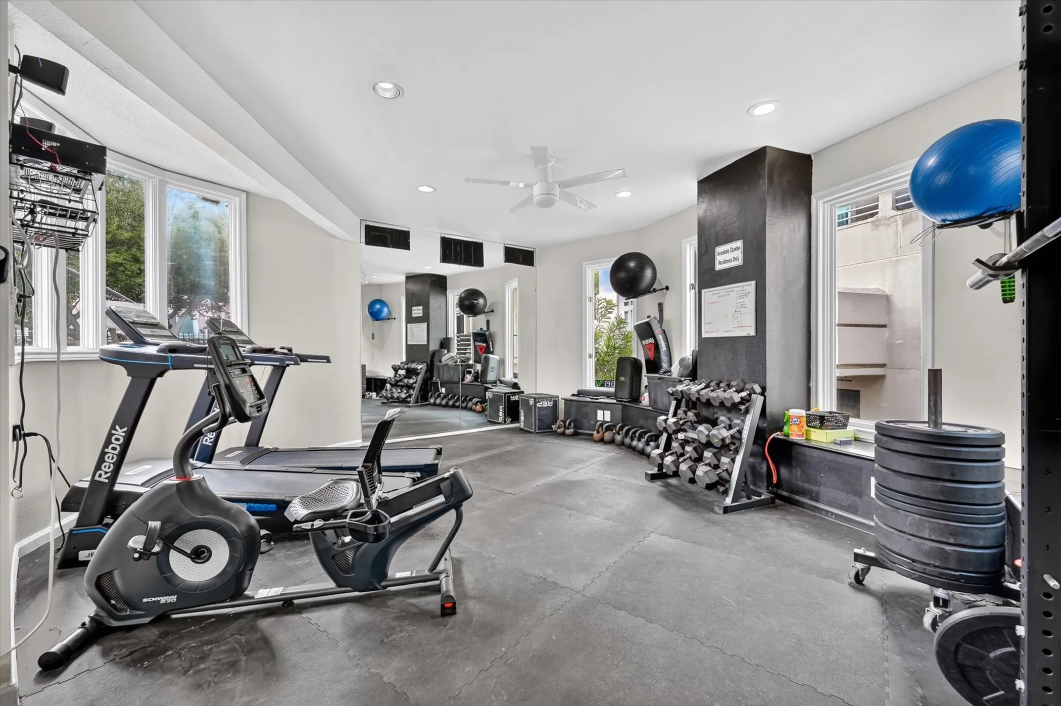 Dedicated fitness space with recessed lighting, ceiling fan, and multiple windows