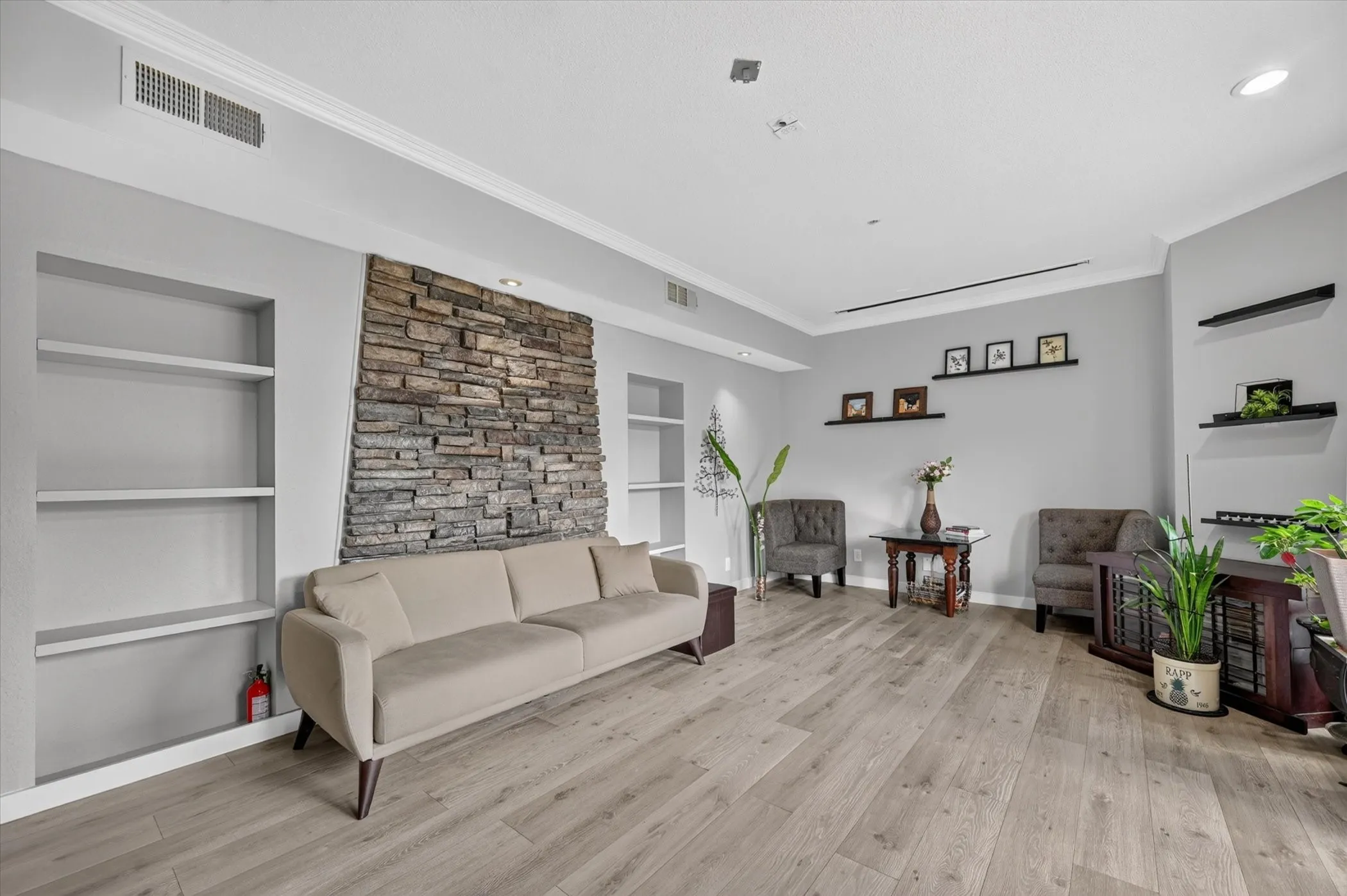 Spacious living area featuring wood-finish flooring, recessed lighting, and crown molding
