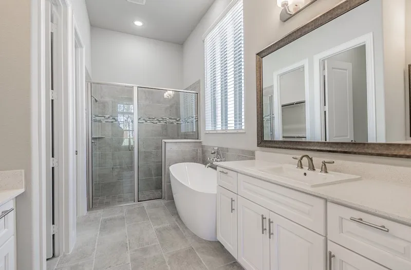 White vanity with a single basin sink, brushed nickel faucet, and a framed mirror
