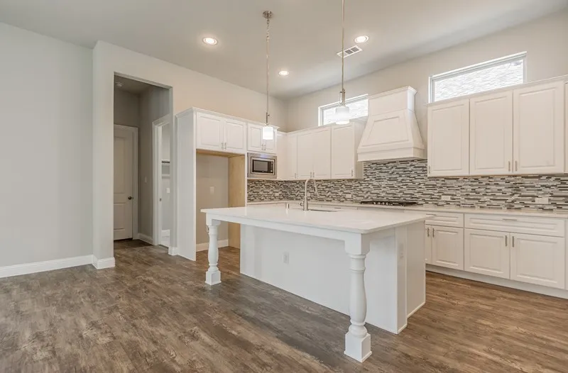 White kitchen cabinetry, mosaic tile backsplash, central island with seating, pendant lighting, and wood-finish flooring