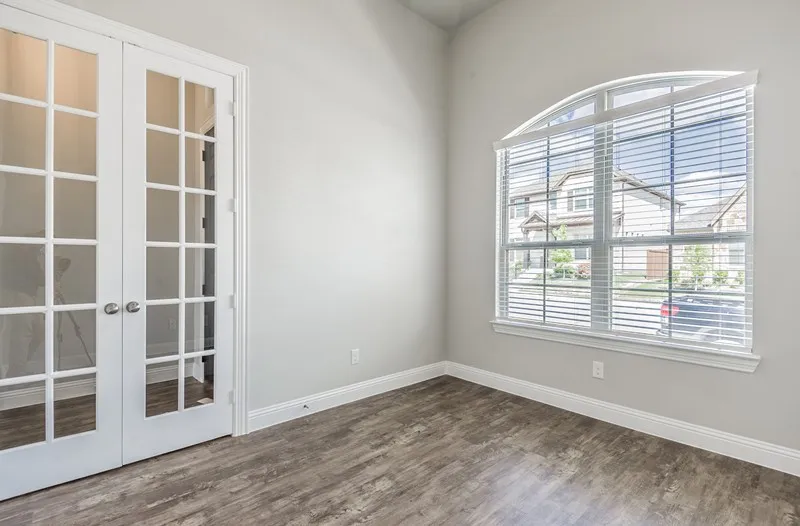 French doors with clear glass panes, an arched window with horizontal blinds, wood-finish flooring, and light-toned walls