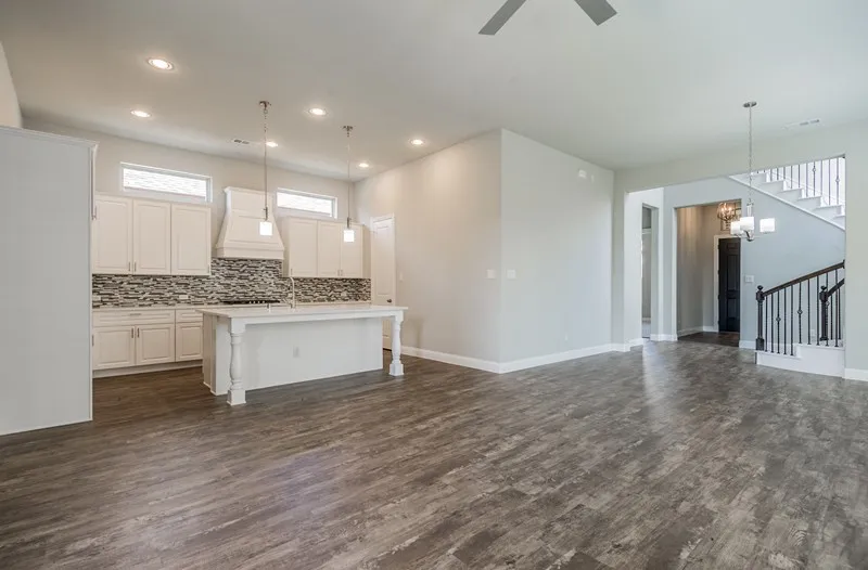Spacious open-concept living area featuring wood-finish flooring, recessed lighting, and a ceiling fan