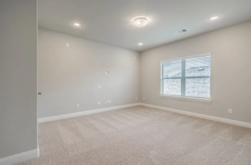 Wall-to-wall carpeting, recessed lighting, and a flush mount ceiling fixture illuminate this space