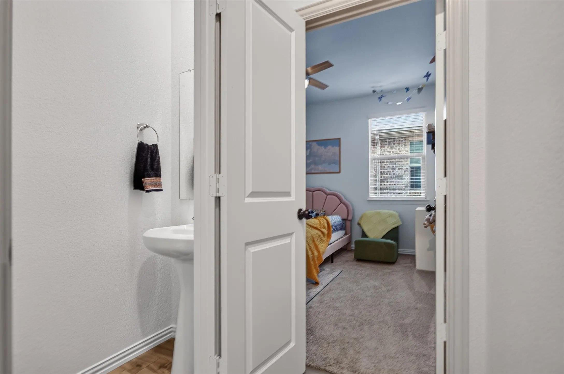 Pedestal sink with wood-finish flooring