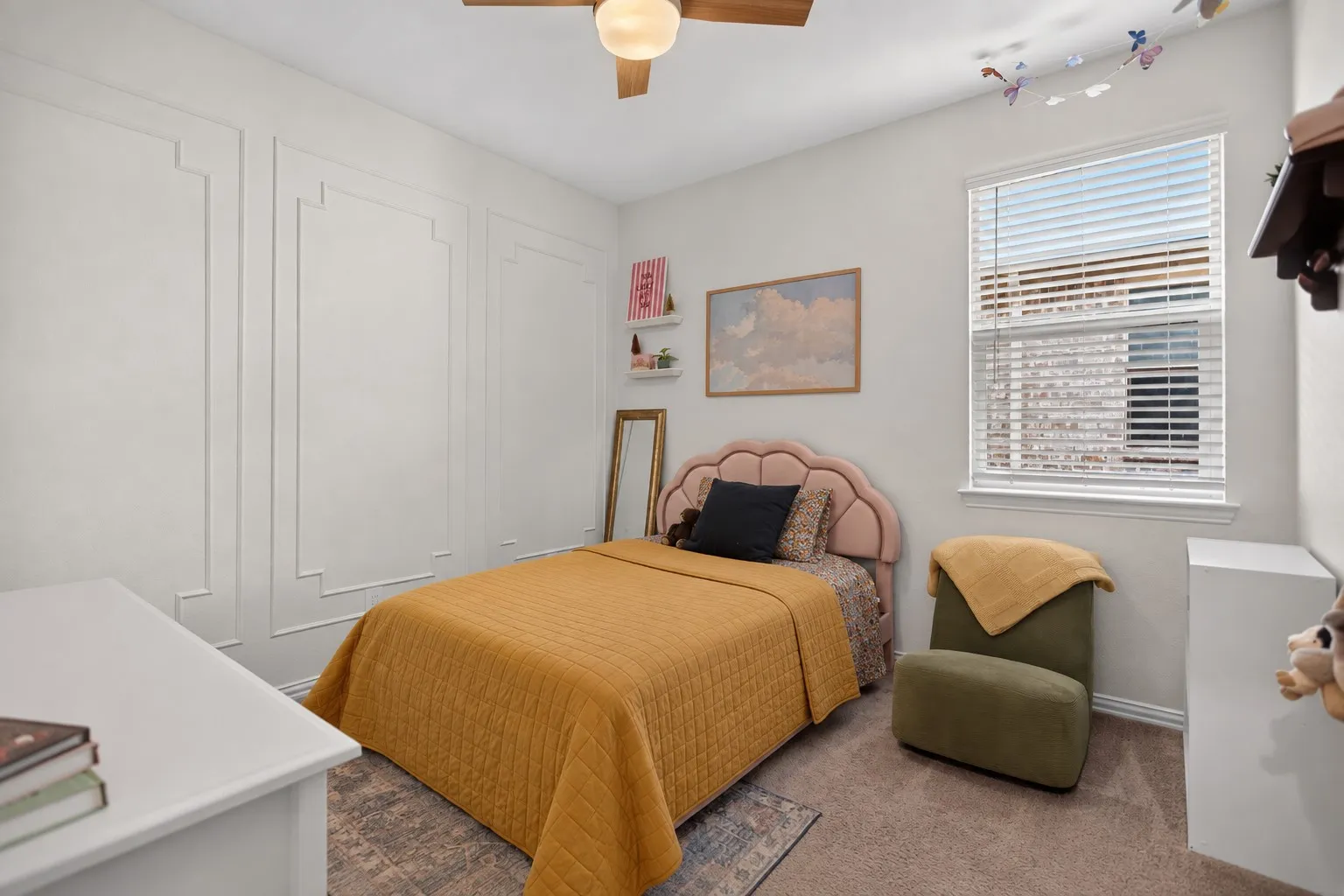 White wall paneling, ceiling fan, window with blinds, and carpeted flooring