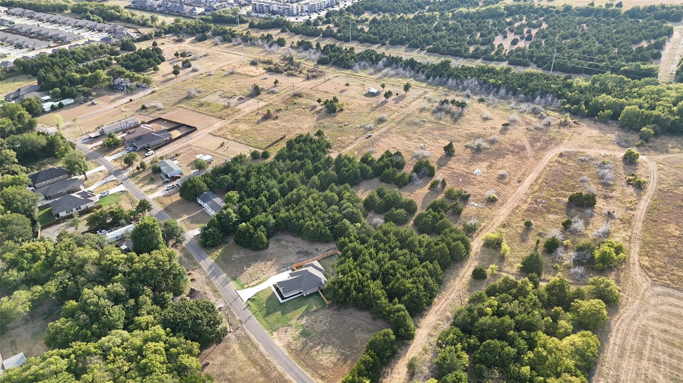 Expansive lot featuring mature trees and a paved driveway