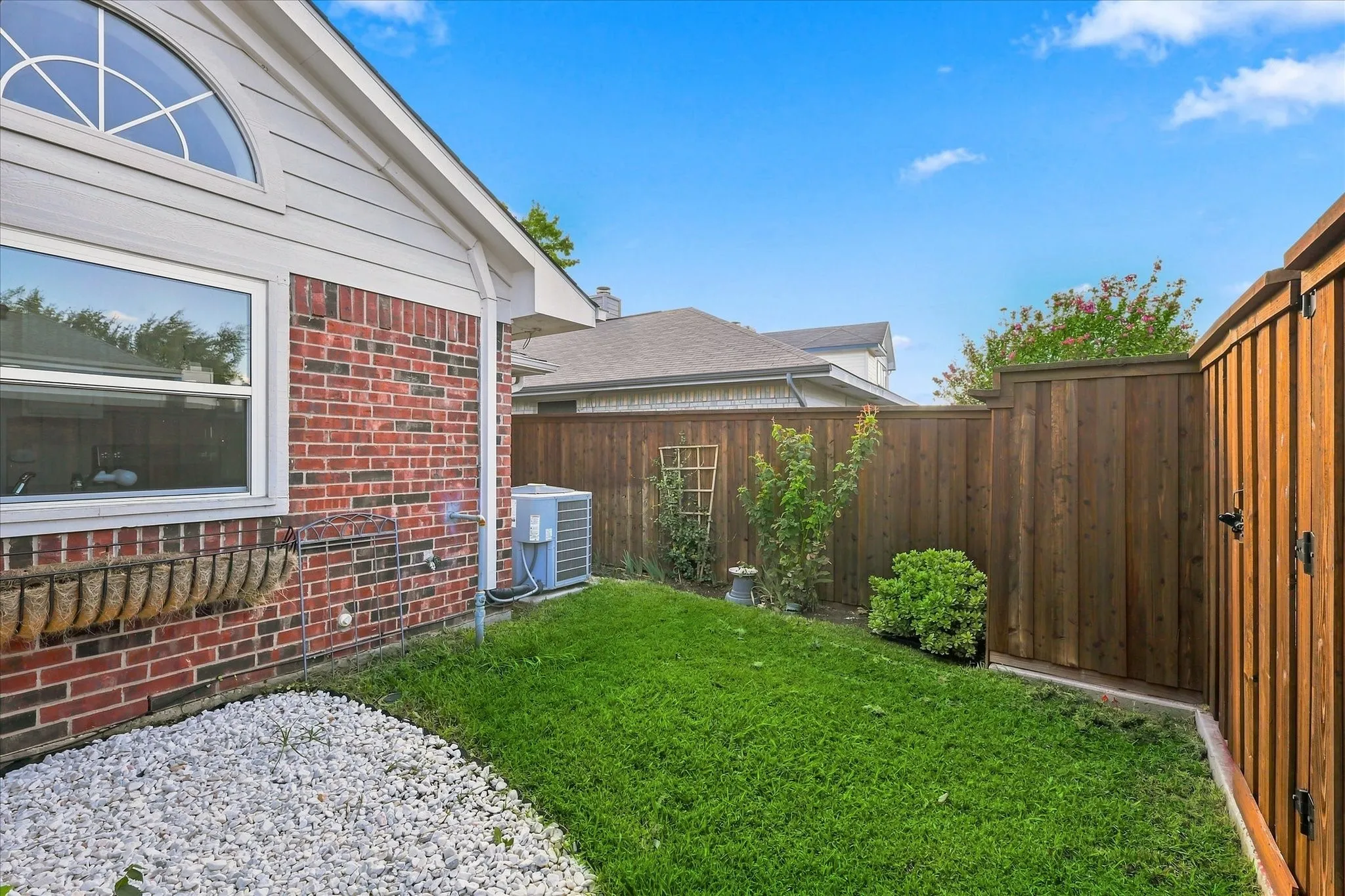 Brick exterior with an arched window and white siding