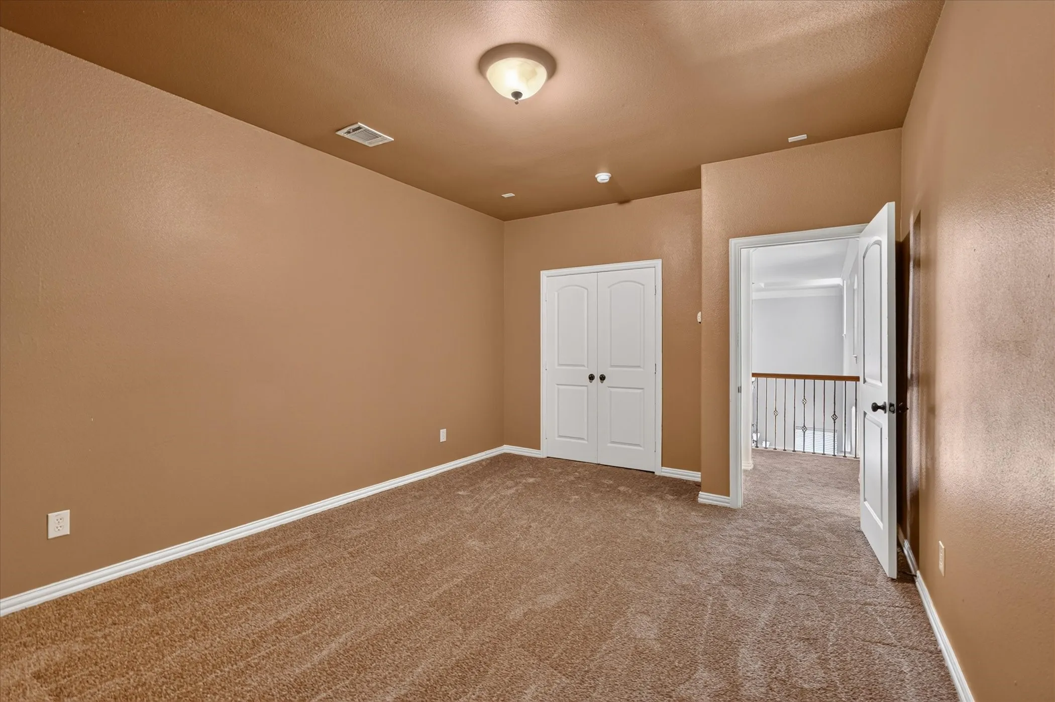 Wall-to-wall carpeting with light-toned walls, white trim, and a flush mount ceiling light