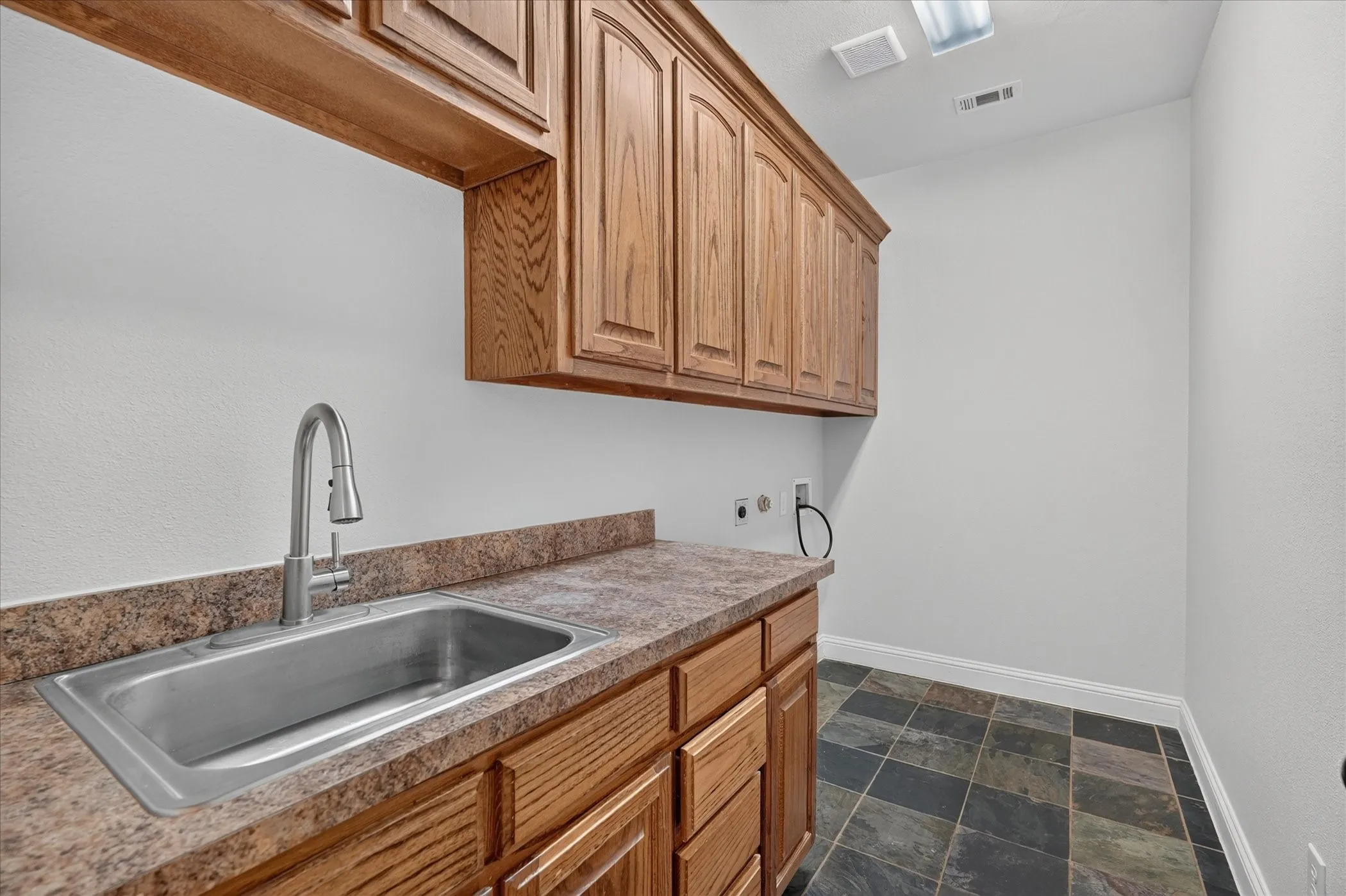 Built-in cabinetry with a stainless steel sink, pull-down faucet, and durable countertop