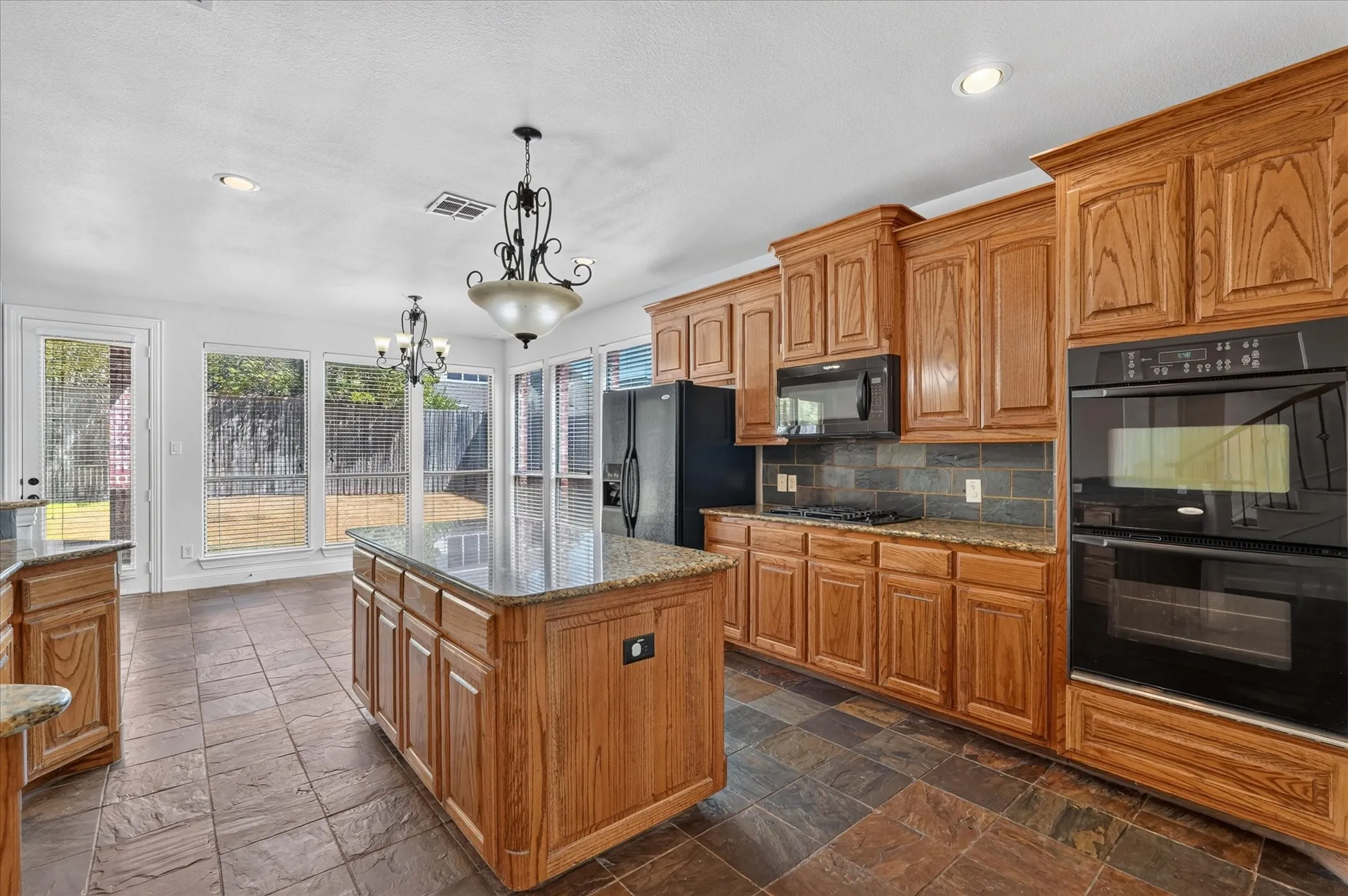 Kitchen featuring a central island, recessed lighting, double wall oven, and built-in microwave