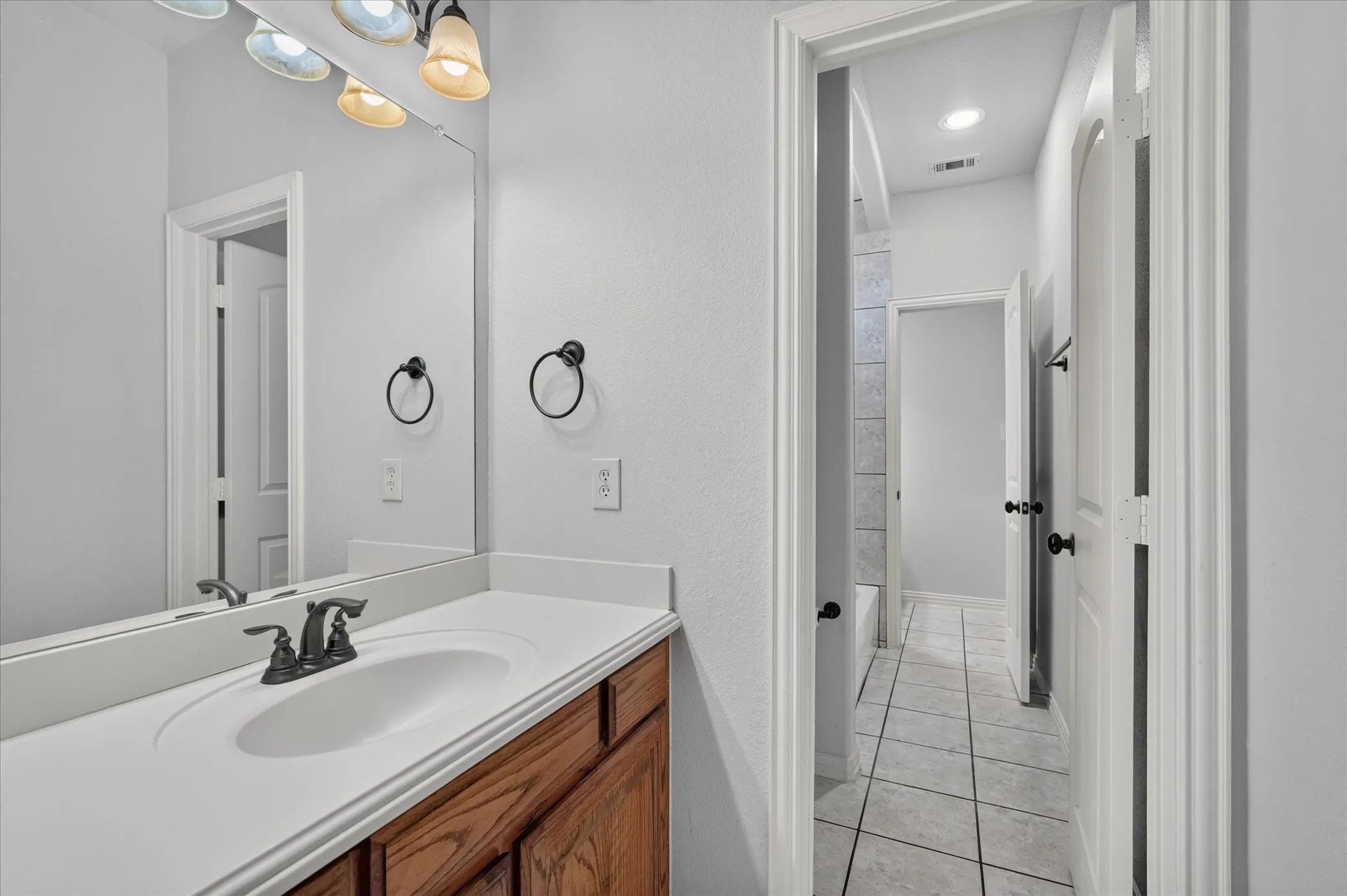 White vanity countertop with an integrated sink and a dark-finish faucet