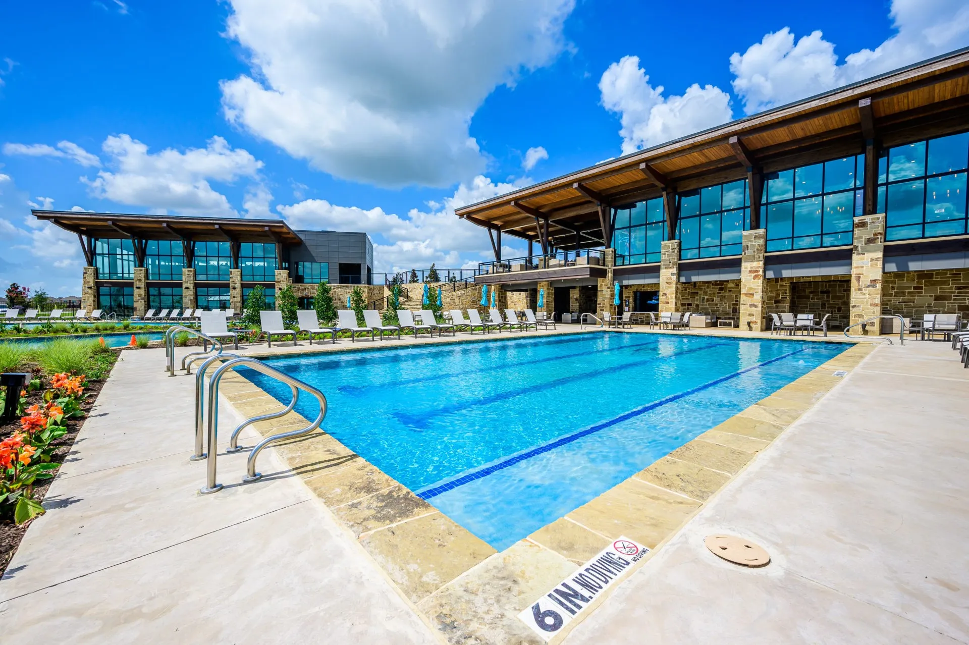 Expansive outdoor swimming pool with integrated lane lines and stainless steel handrails