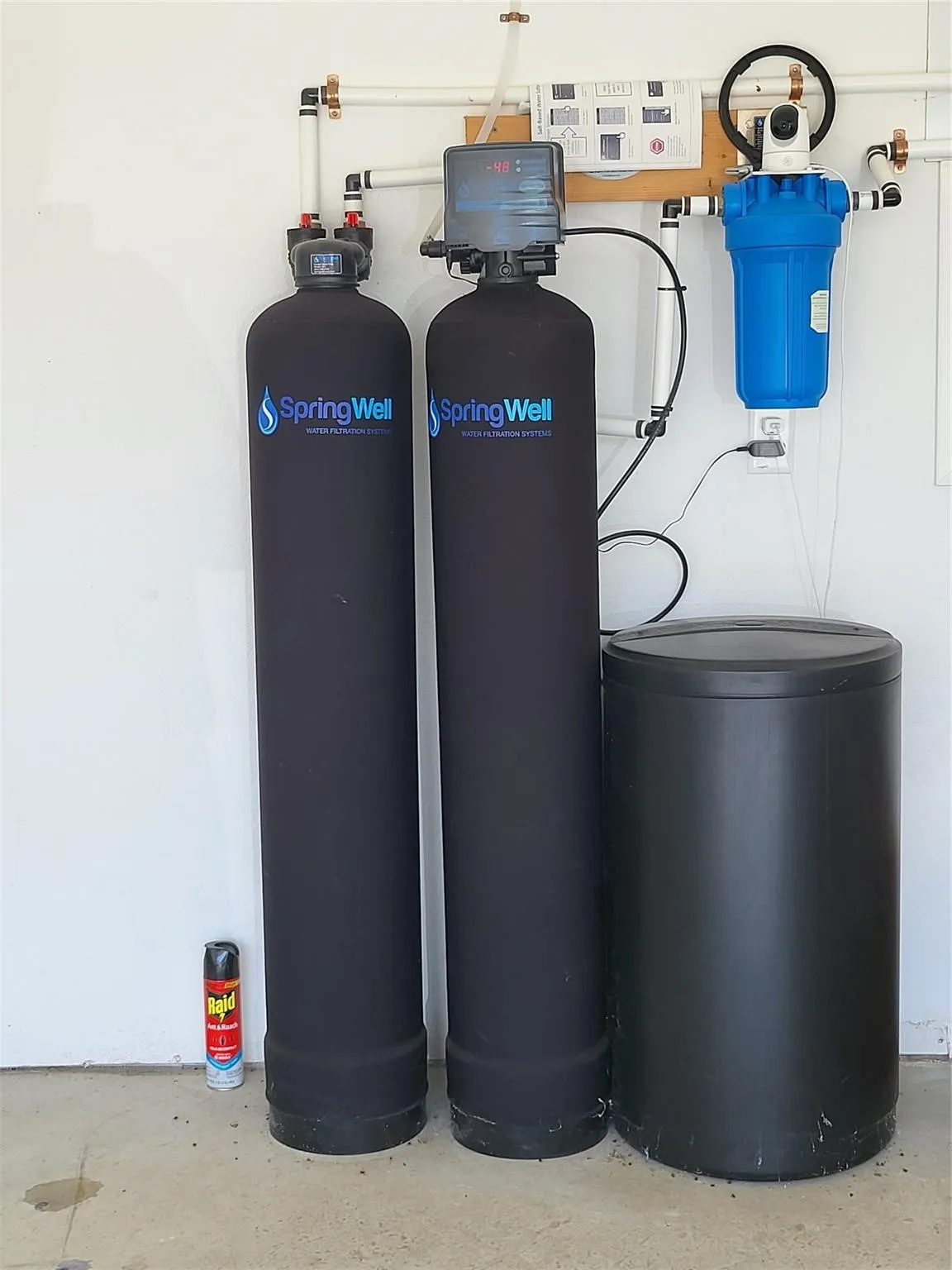 Water filtration system featuring two filtration tanks, a pre-filter, and associated plumbing