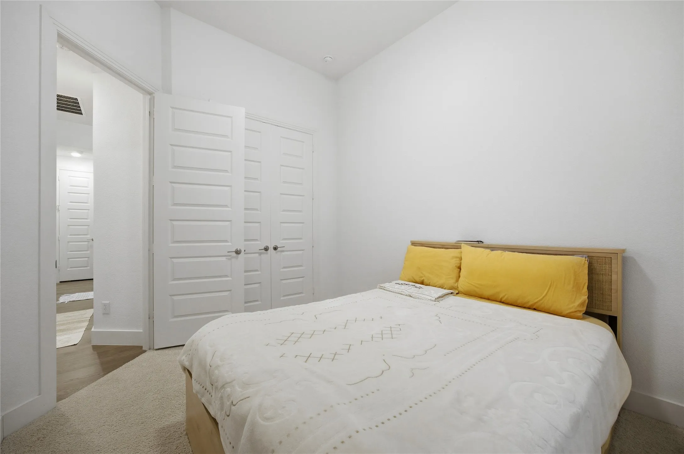 White paneled interior doors, light beige carpet flooring, and a vaulted ceiling