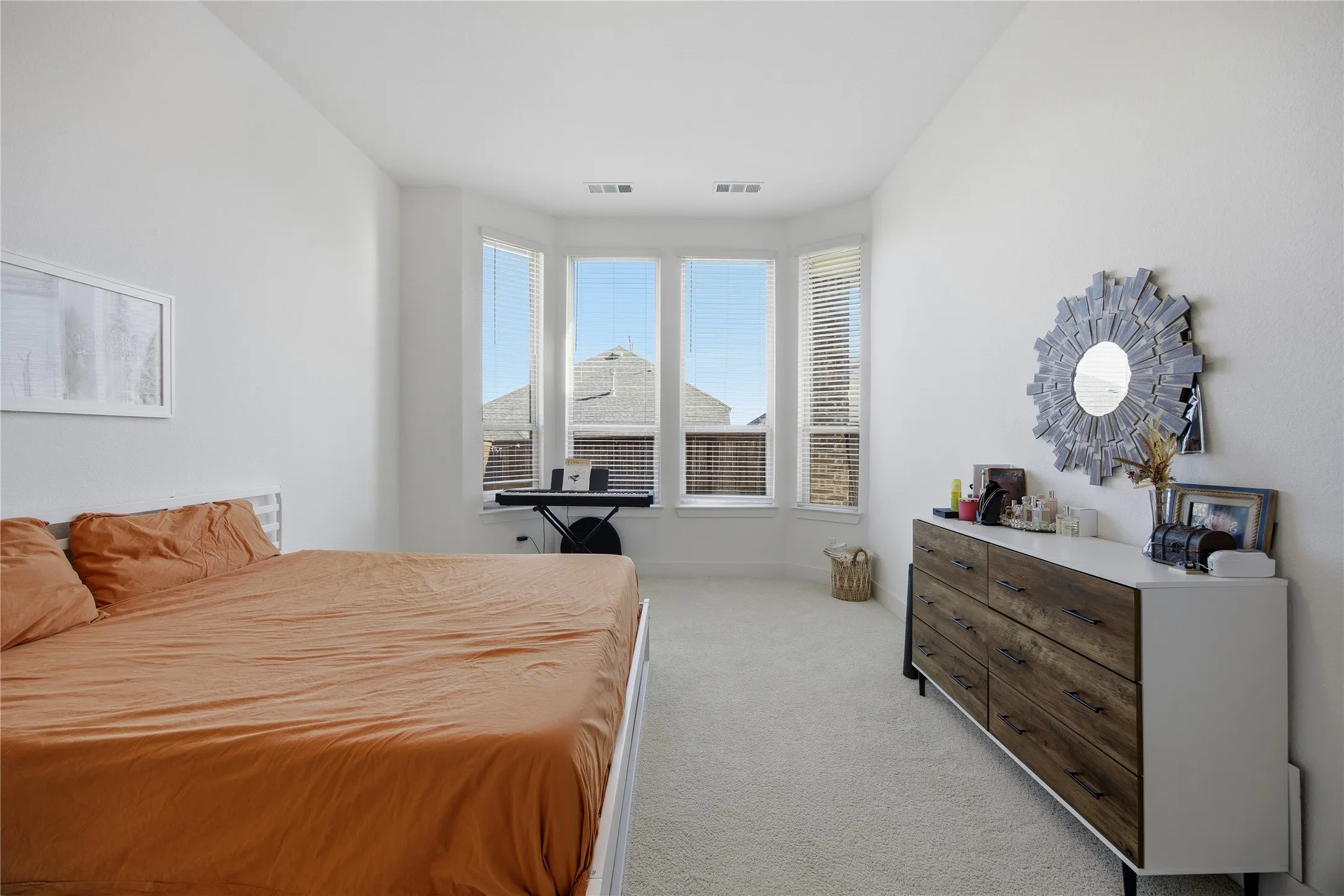 Bay window with multiple panels, textured walls, and light-colored carpeting