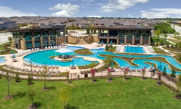 Community amenity center featuring a multi-level pool, lap pool, and a winding lazy river