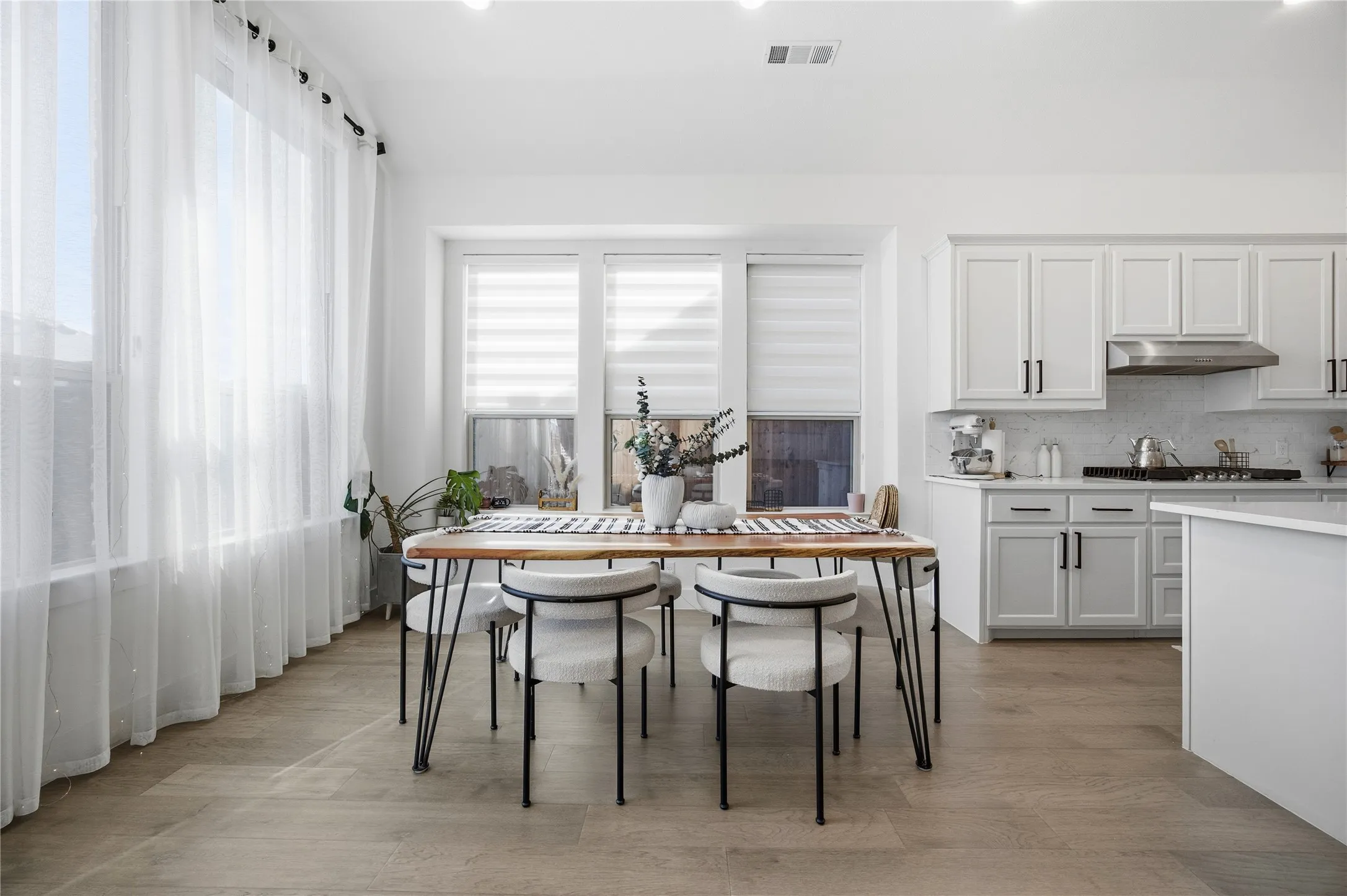 Open-concept dining area with wood-finish flooring, recessed lighting, and kitchen access