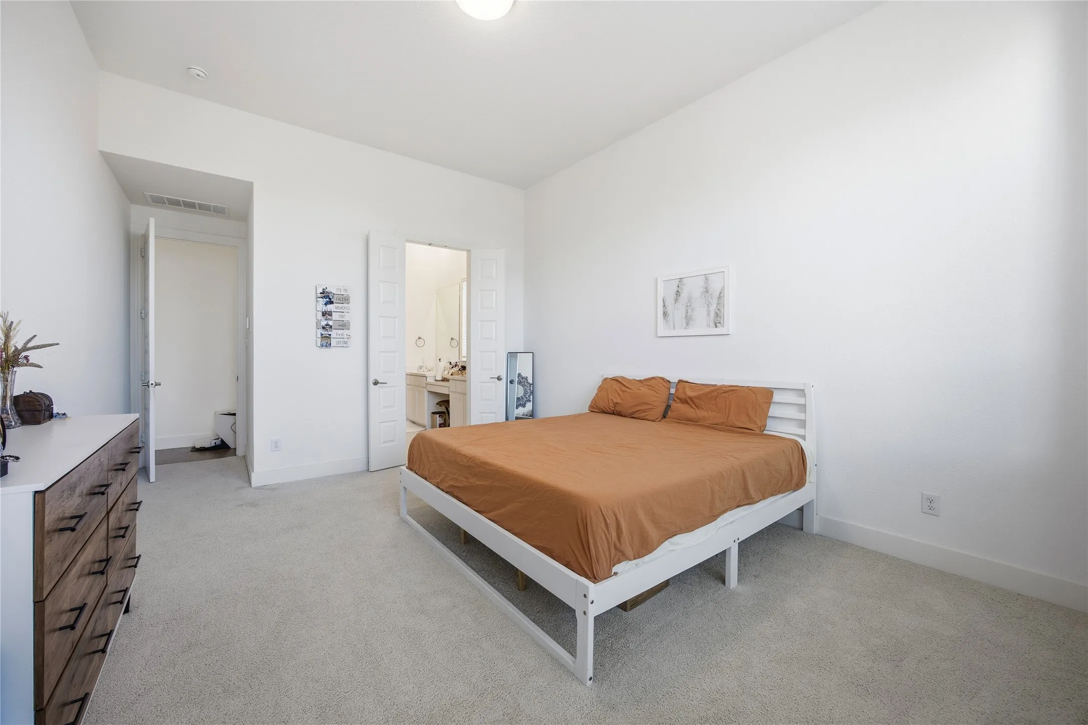 Plush carpet flooring, tall ceilings, and a light color palette