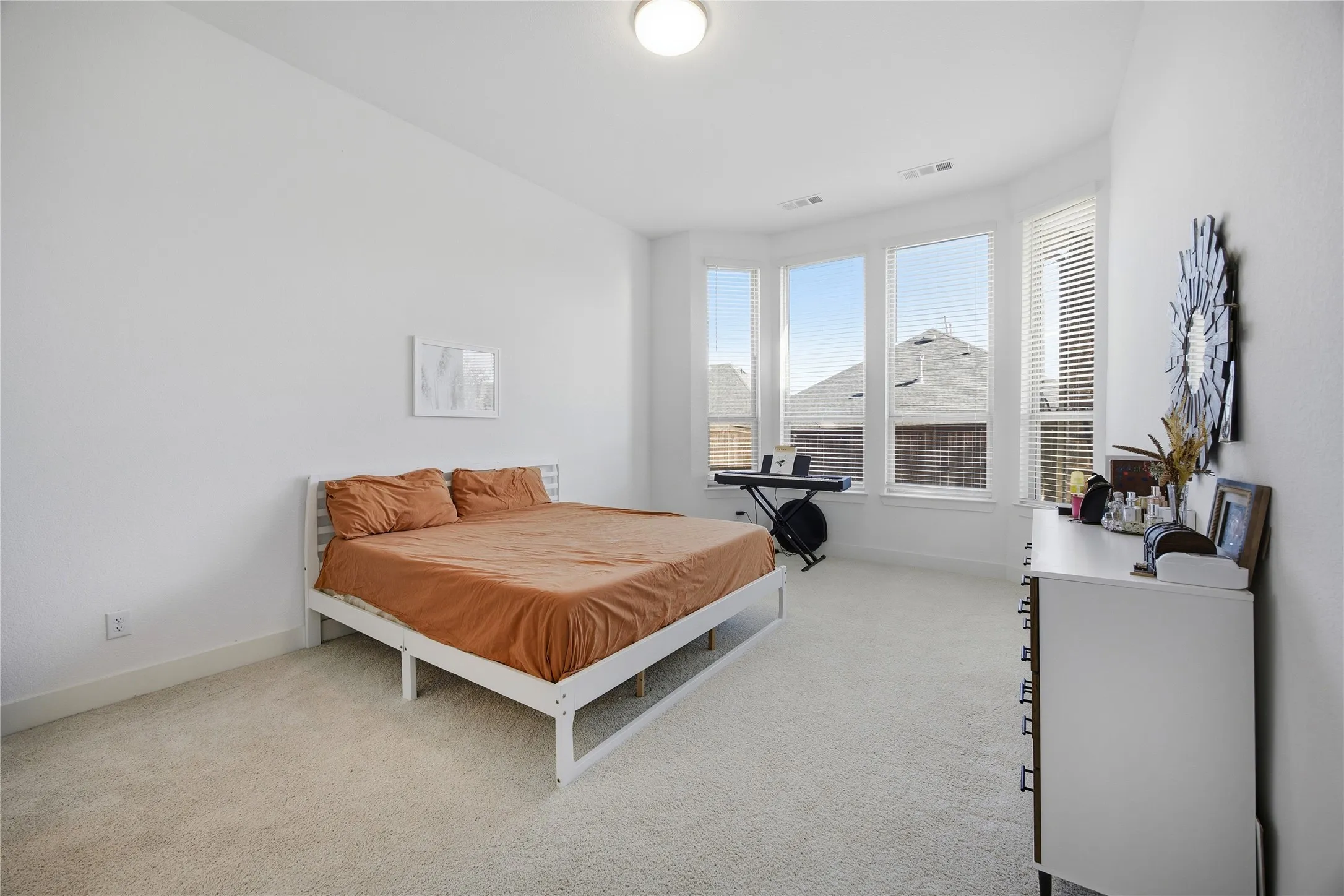 Room featuring light-toned carpeting and a bay window with multiple panes