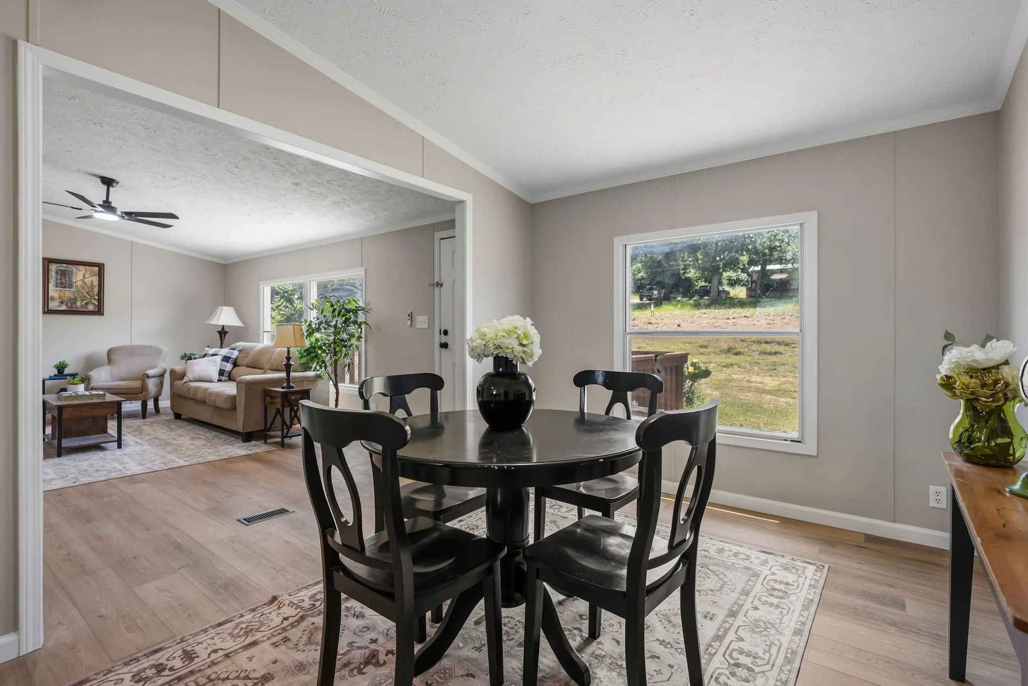 Wood-finish flooring throughout, light-toned wall paneling, and an open archway