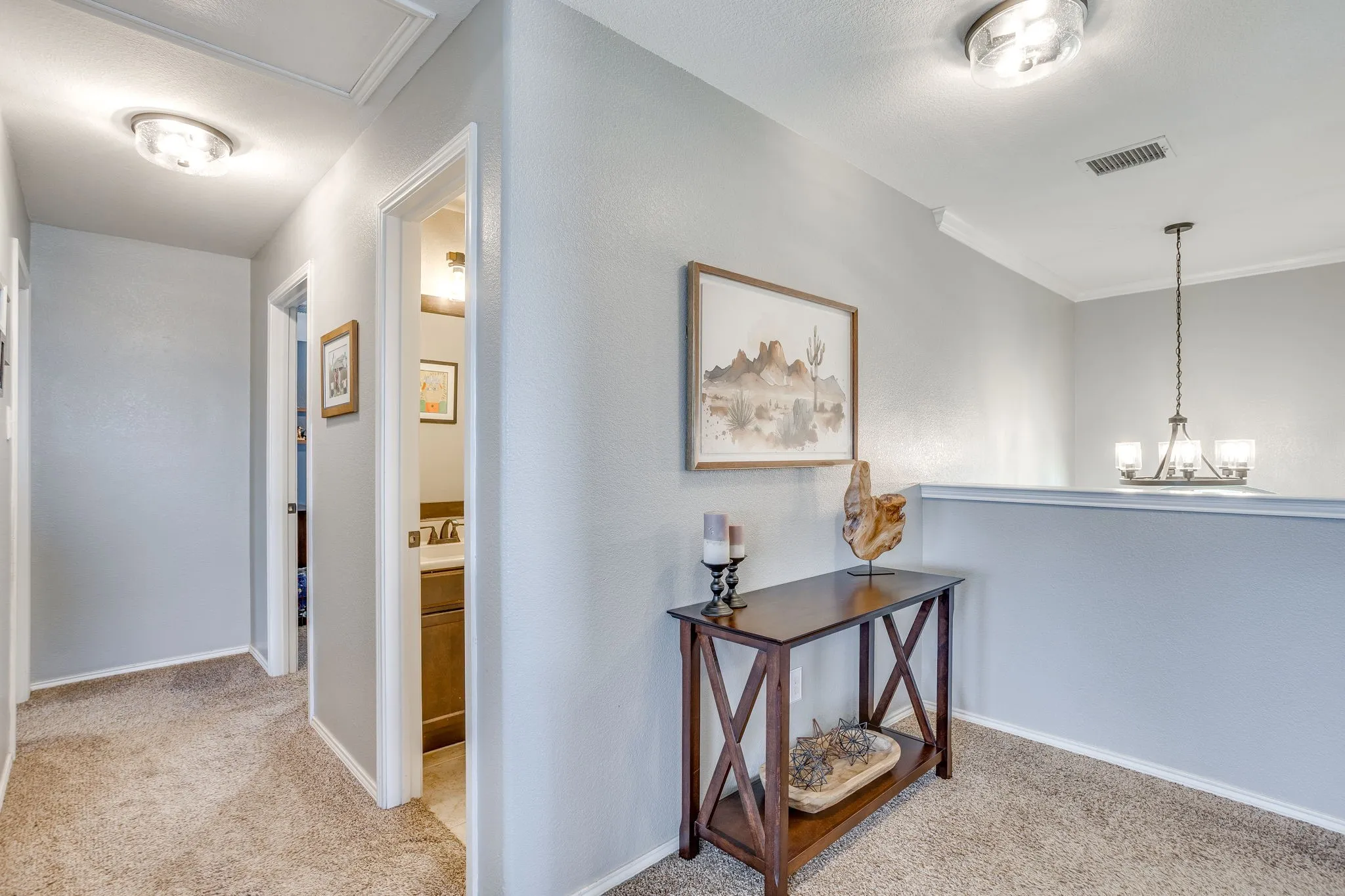 Carpeted flooring, light gray wall paint, recessed lighting, crown molding, and a built-in chandelier