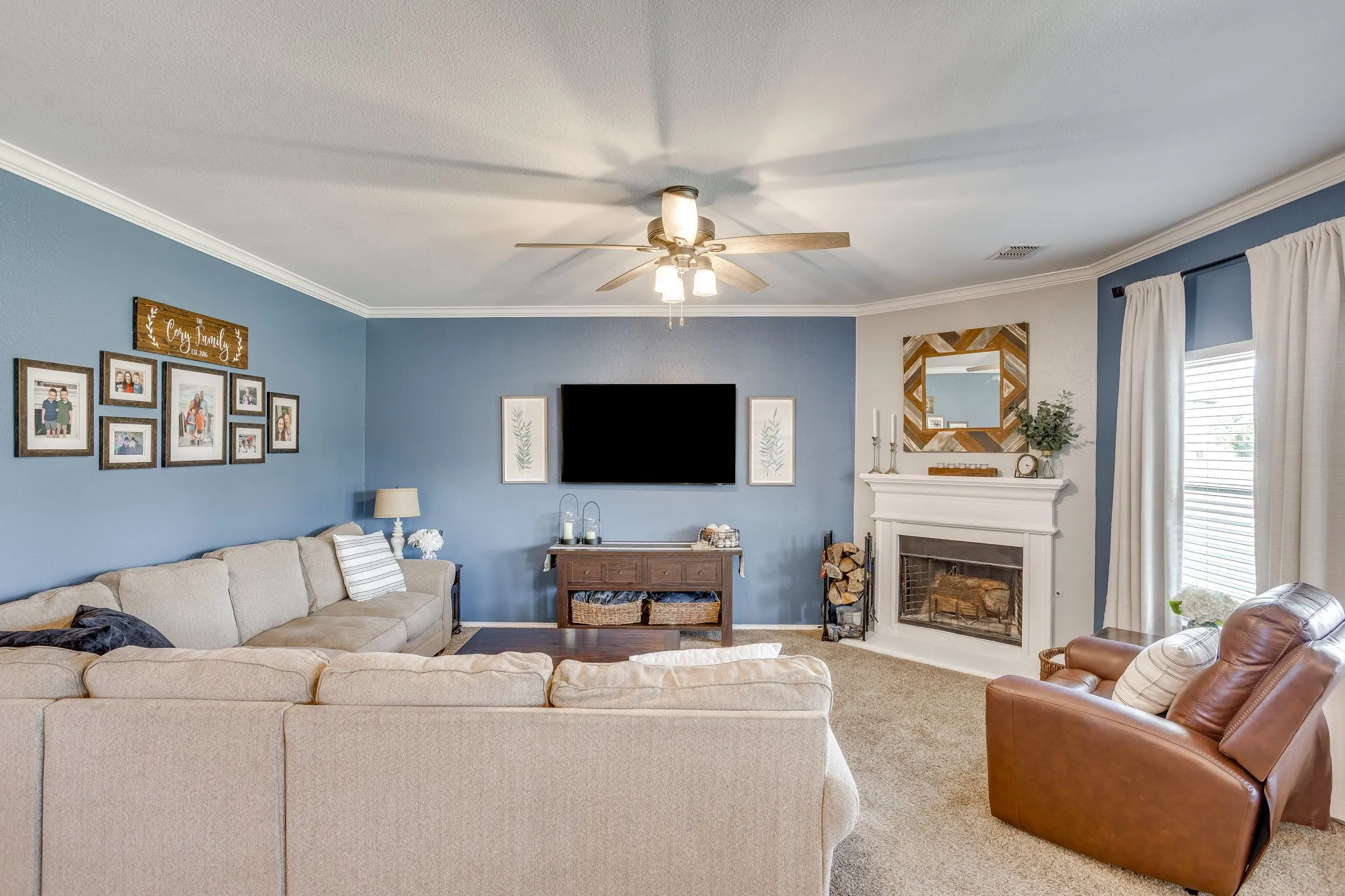 Recessed lighting, crown molding, ceiling fan, fireplace with mantel, and window with blinds