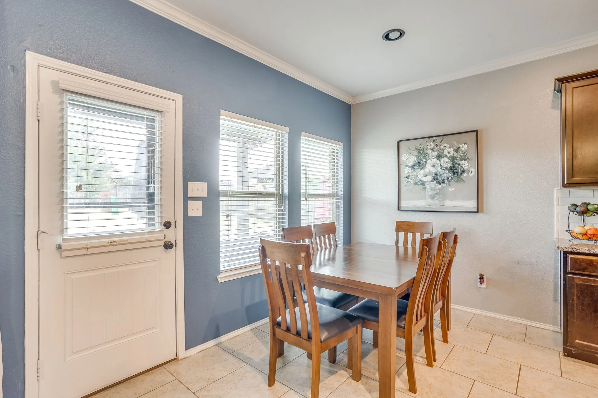 Neutral ceramic tile flooring, recessed ceiling lighting, crown molding, and multiple windows