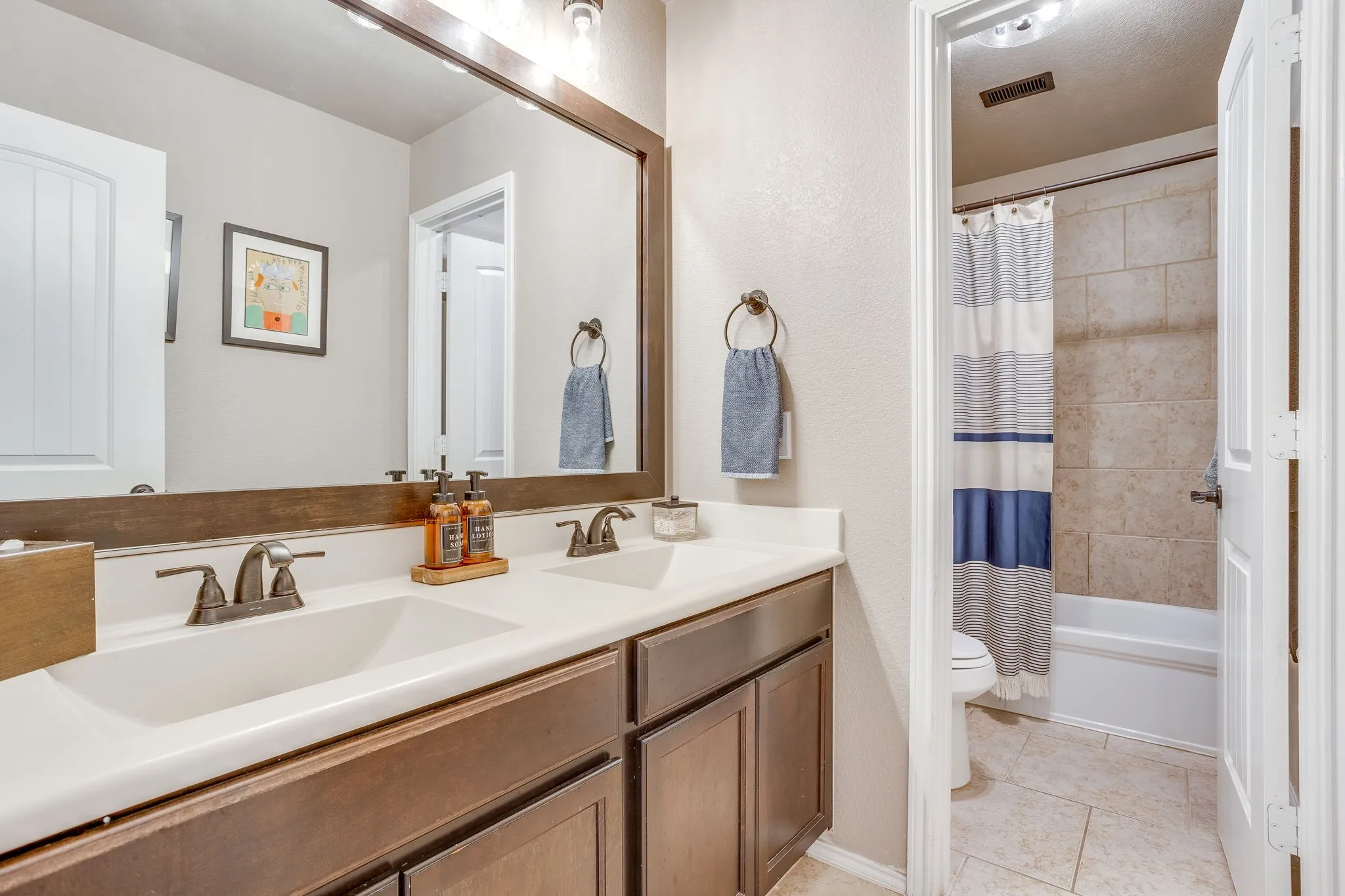 Dual vanity with integrated sinks and dark wood-finish cabinetry