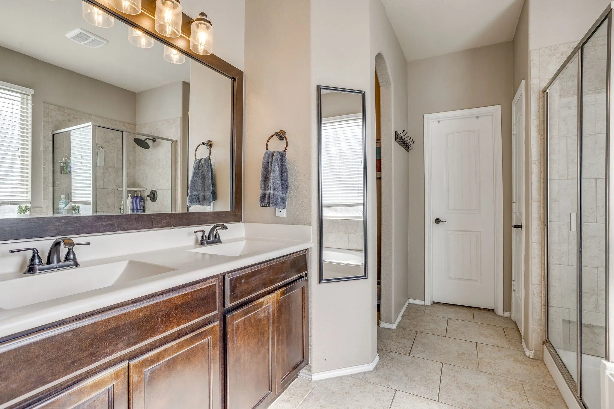 Dual vanity with wood-finish cabinetry and bronze-finish fixtures