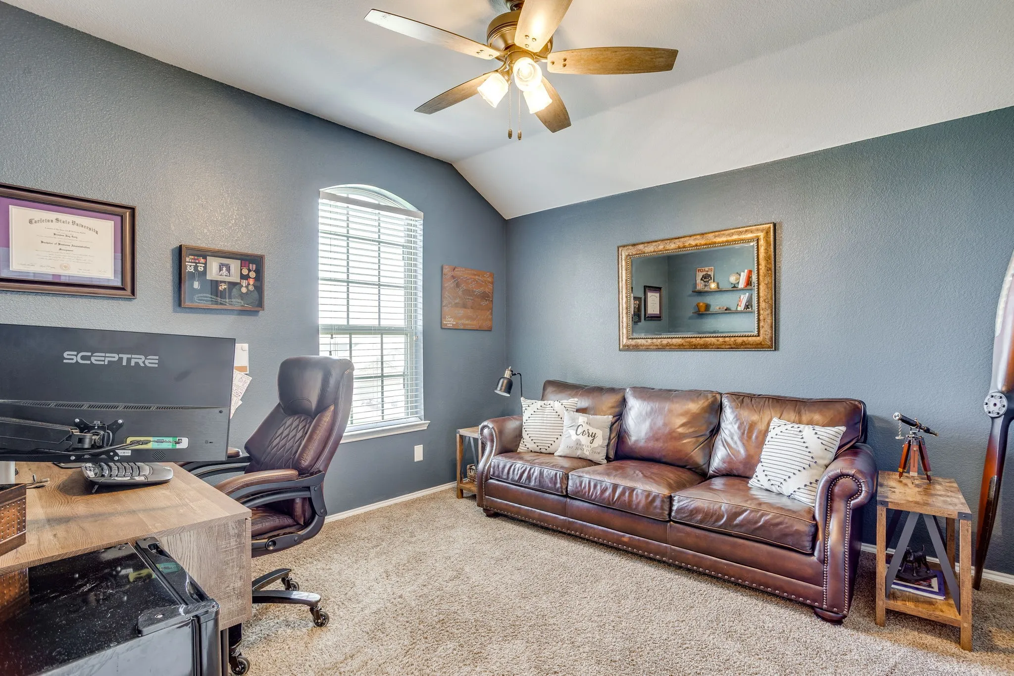 Vaulted ceiling with an attached ceiling fan, arched window with horizontal blinds, and carpeted flooring