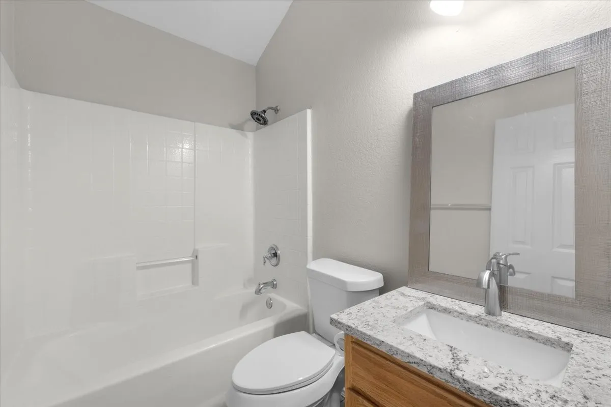 White tub and shower combination with a chrome shower head and fixtures