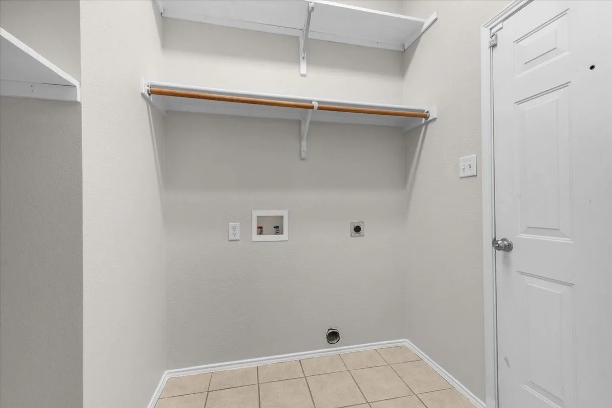 Integrated utility connections, overhead shelving, clothes hanging rod, and ceramic tile flooring