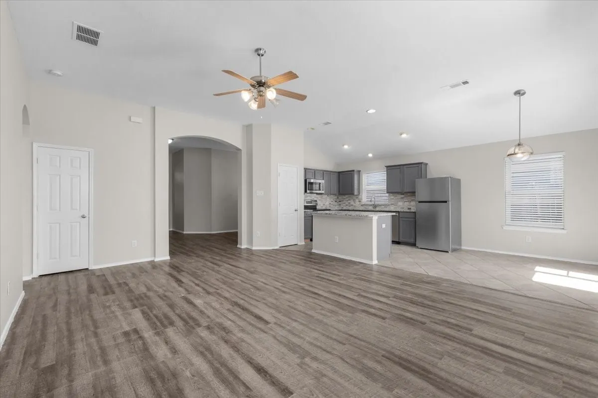 Open-concept living space featuring wood-finish flooring, recessed lighting, and a ceiling fan