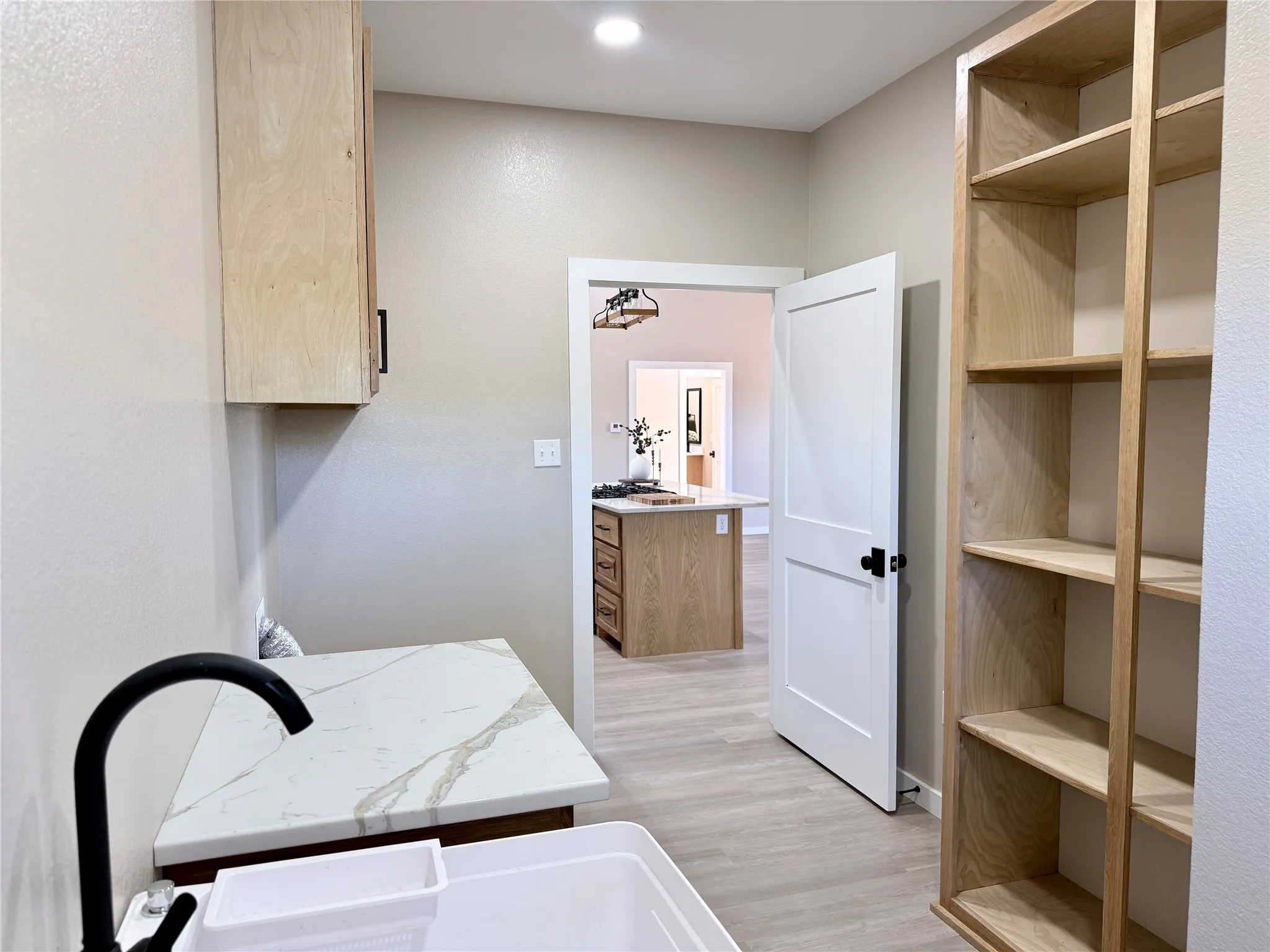 Utility room with open shelving pantry