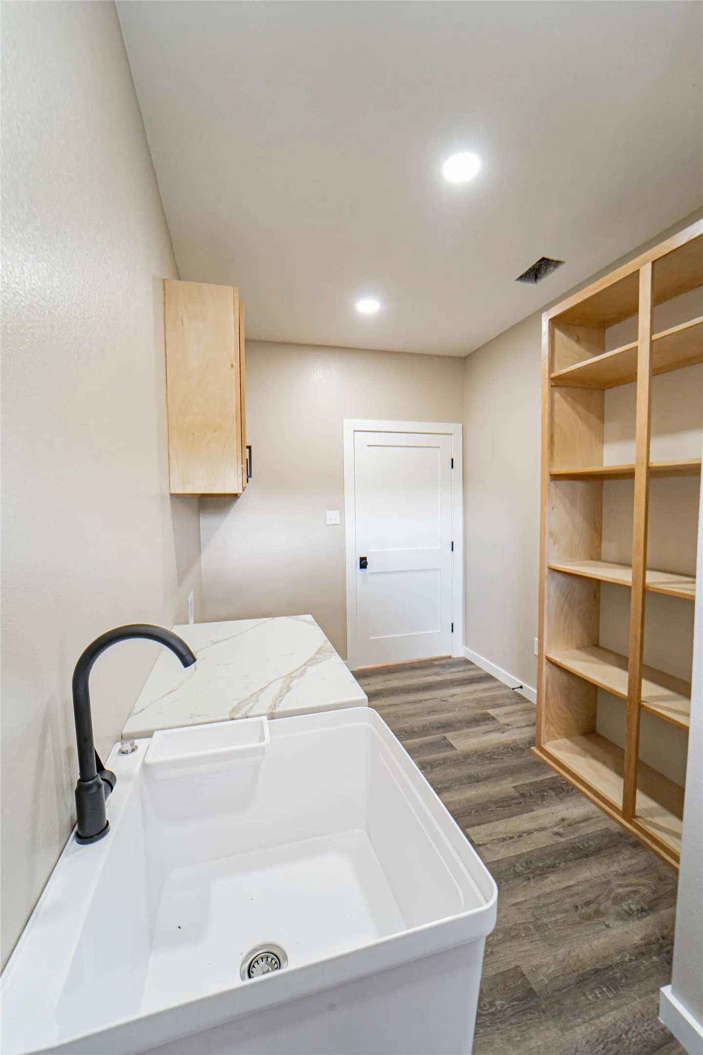 Pantry-Mudroom with utility sink with matte black faucet, wood-finish flooring, white countertop, built-in shelving, and recessed lighting