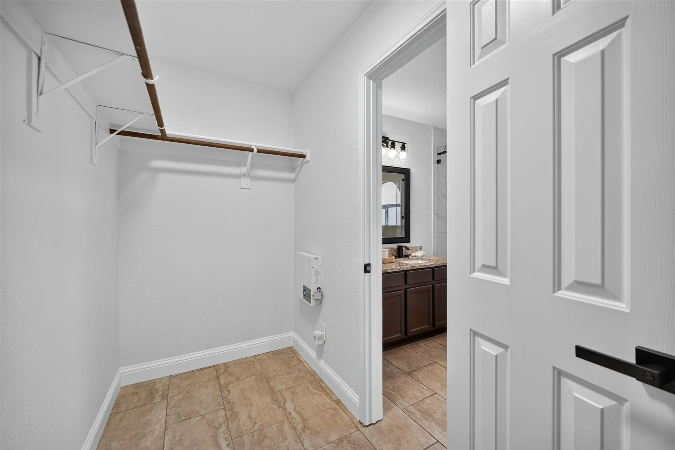 Spacious closet with tile flooring and built-in shelving