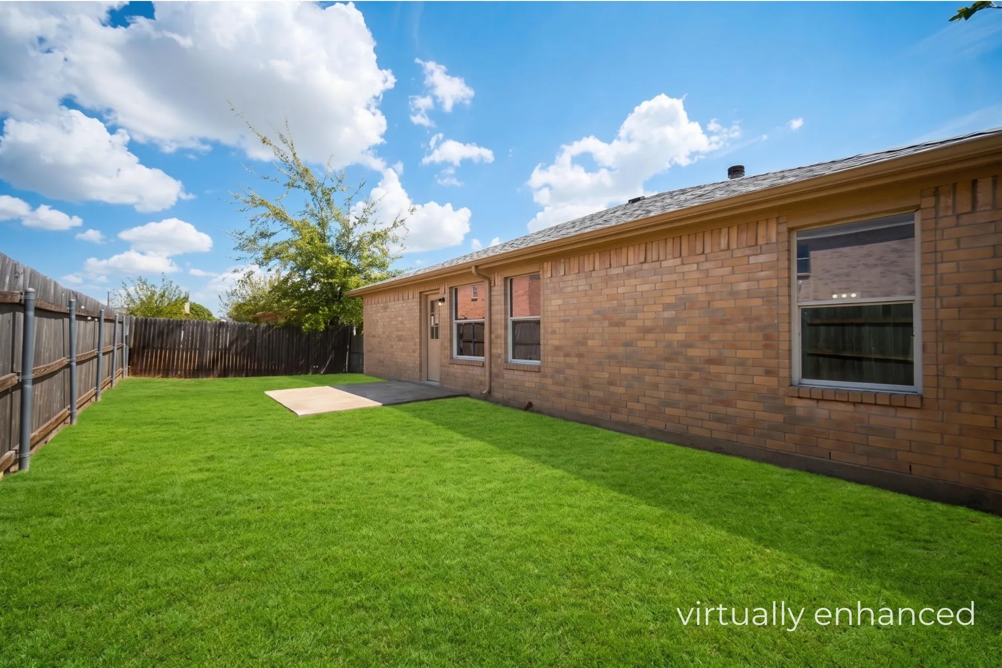 Private backyard with wood fencing, a stone patio, and a grass lawn