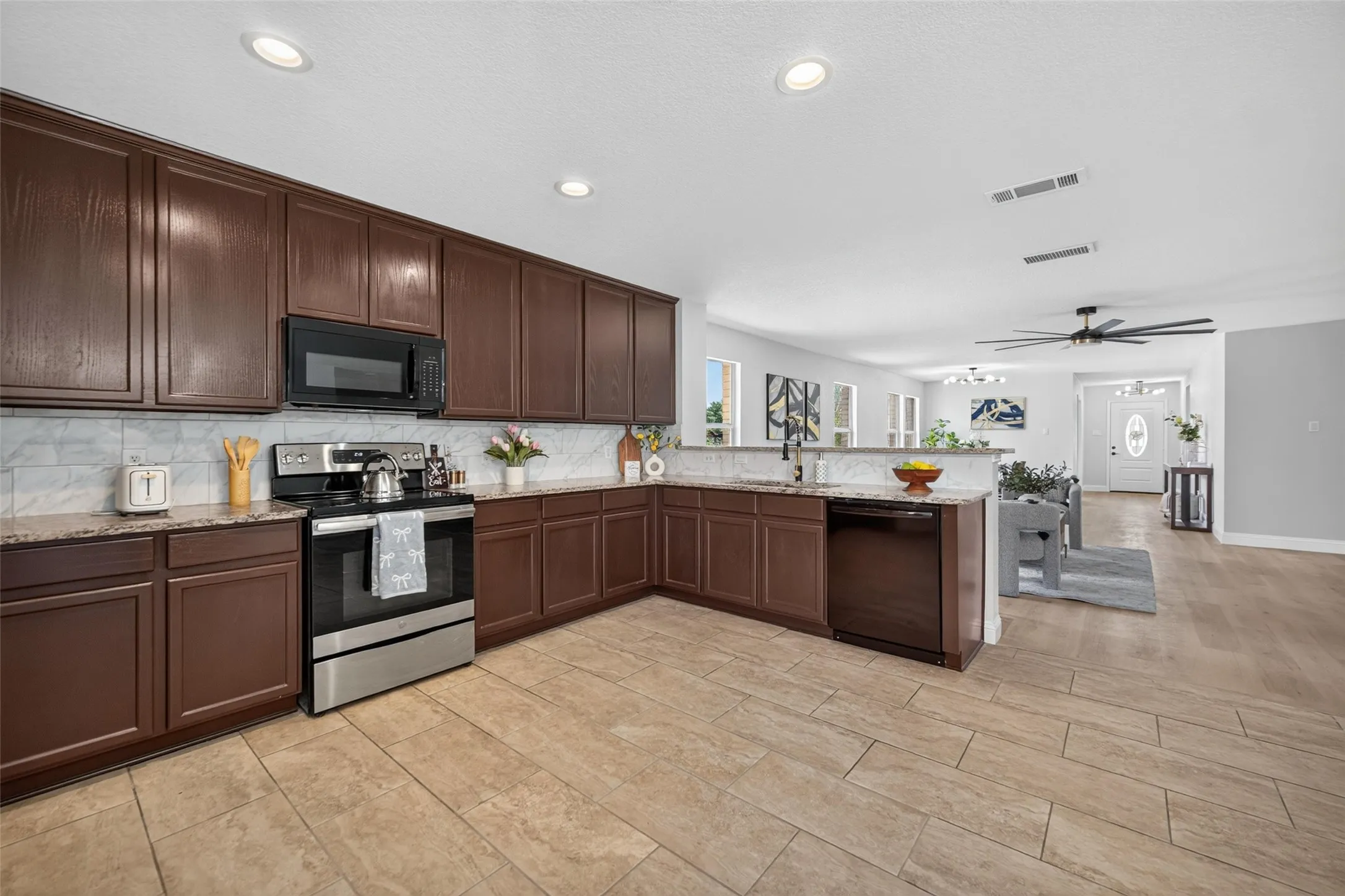 Kitchen featuring brown cabinetry, stone countertops, and stainless steel appliances