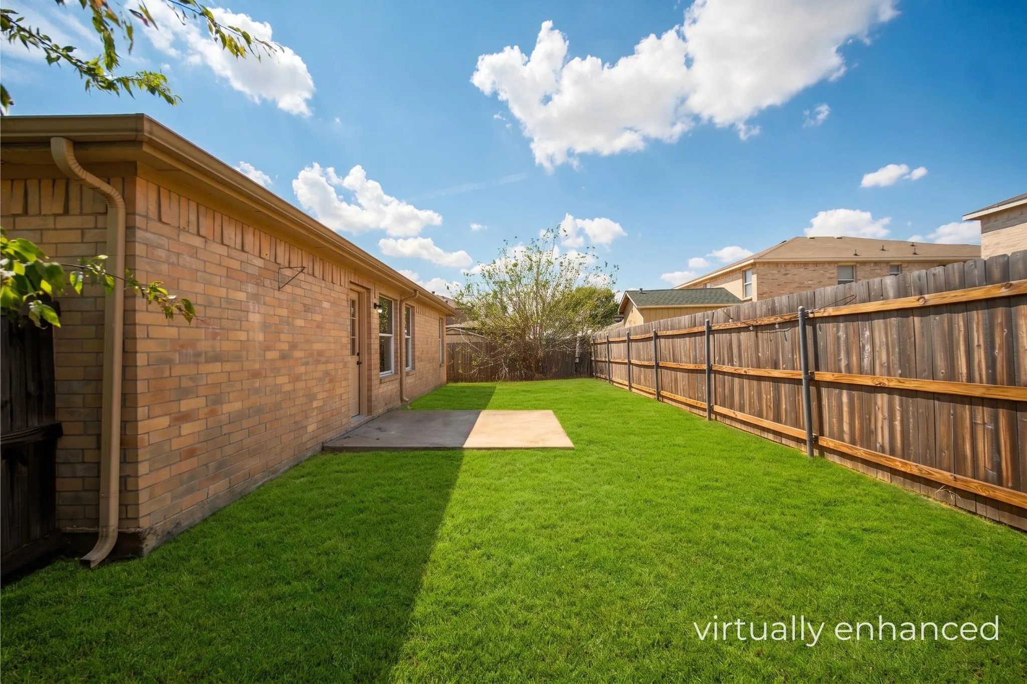 Expansive green lawn with a privacy fence