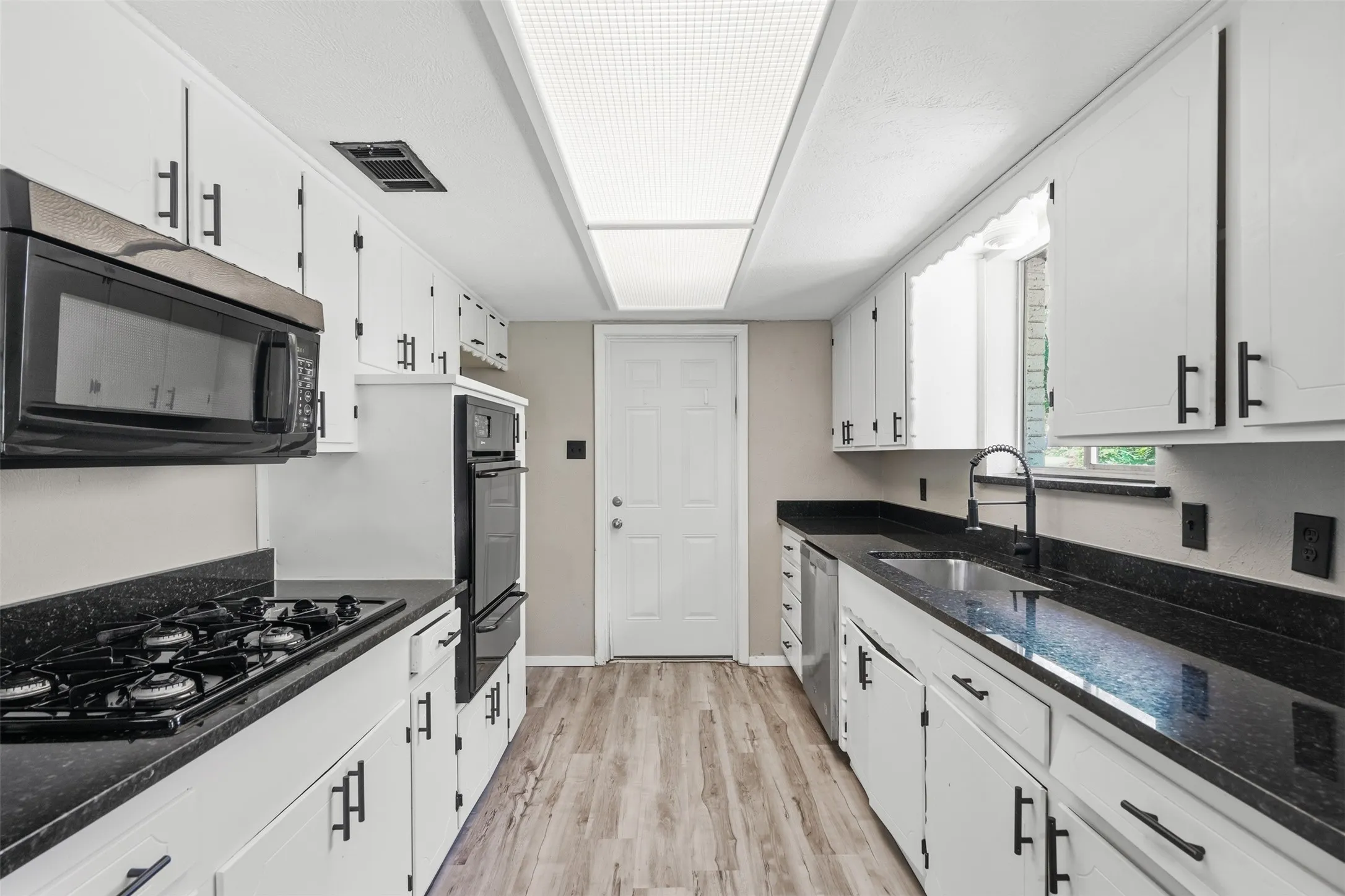 Galley style kitchen opens to den