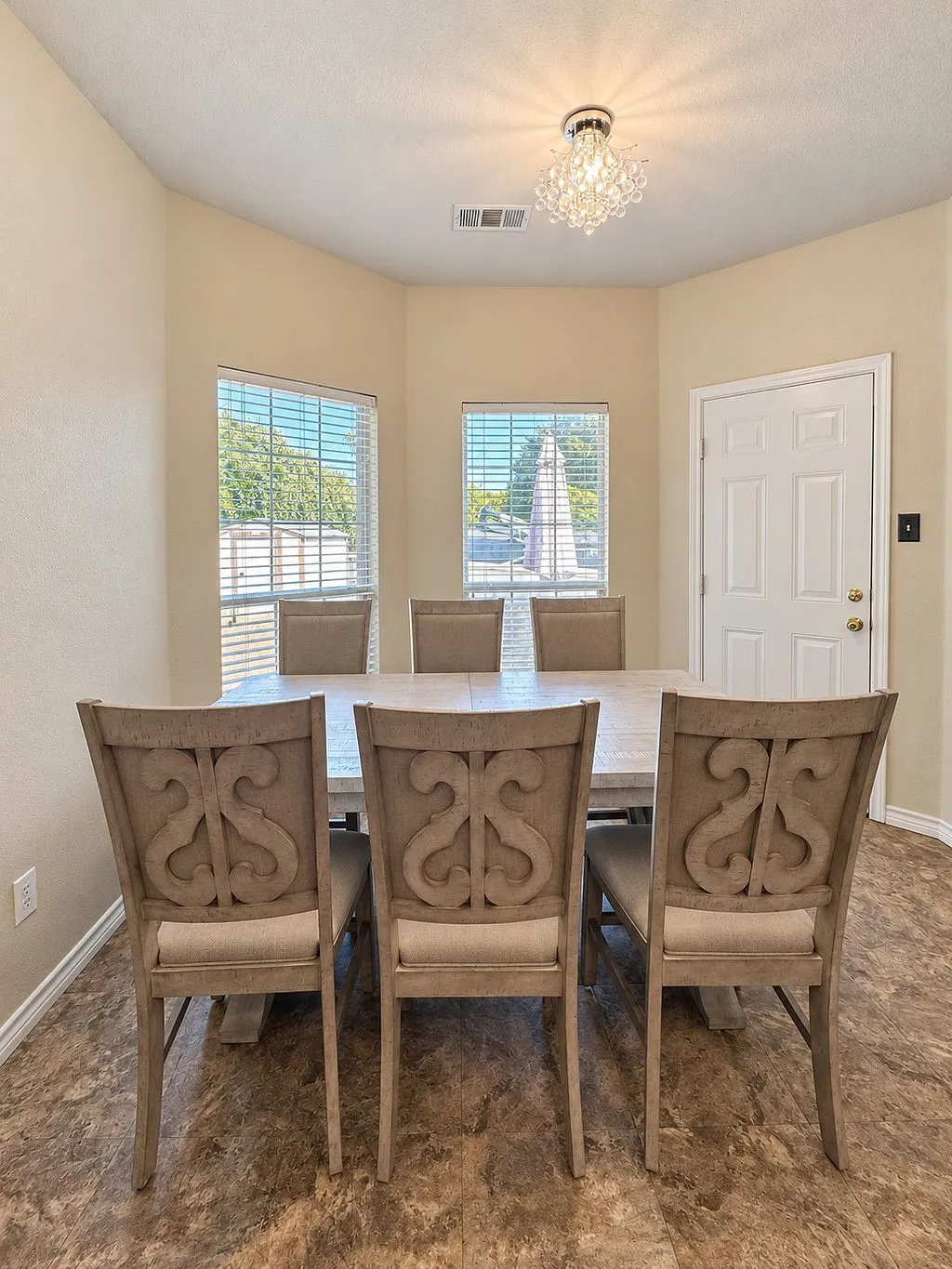 Recessed lighting, chandelier, multiple windows with blinds, and a paneled interior door