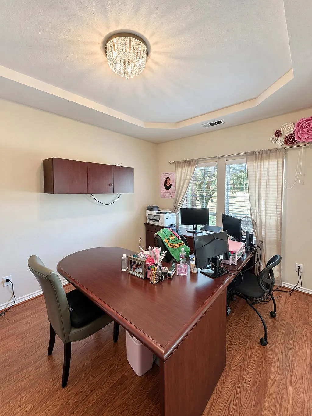 Tray ceiling with a crystal chandelier, wood-finish flooring, and built-in wall cabinetry